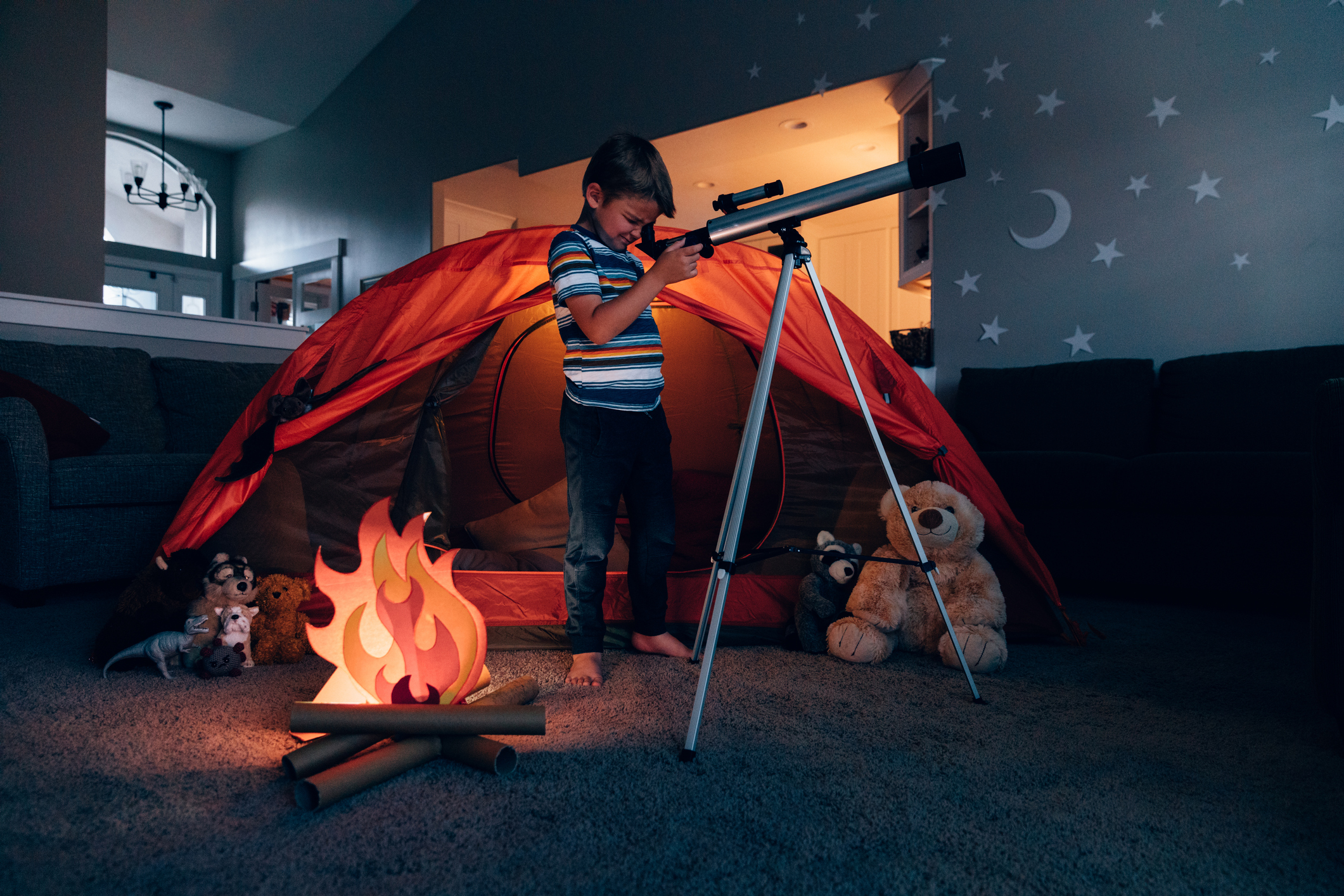 Boy Exploring with Telescope Indoors