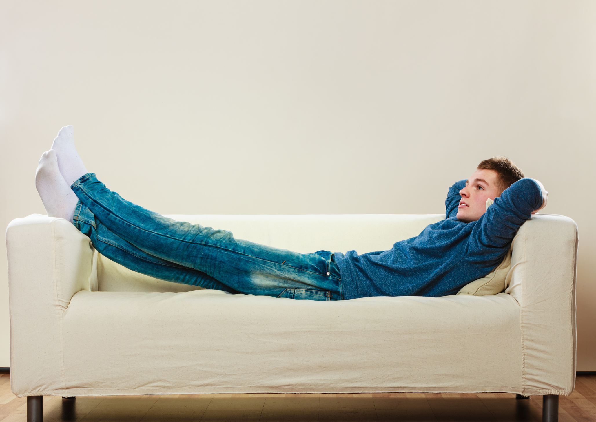 Young pensive man relaxing on couch