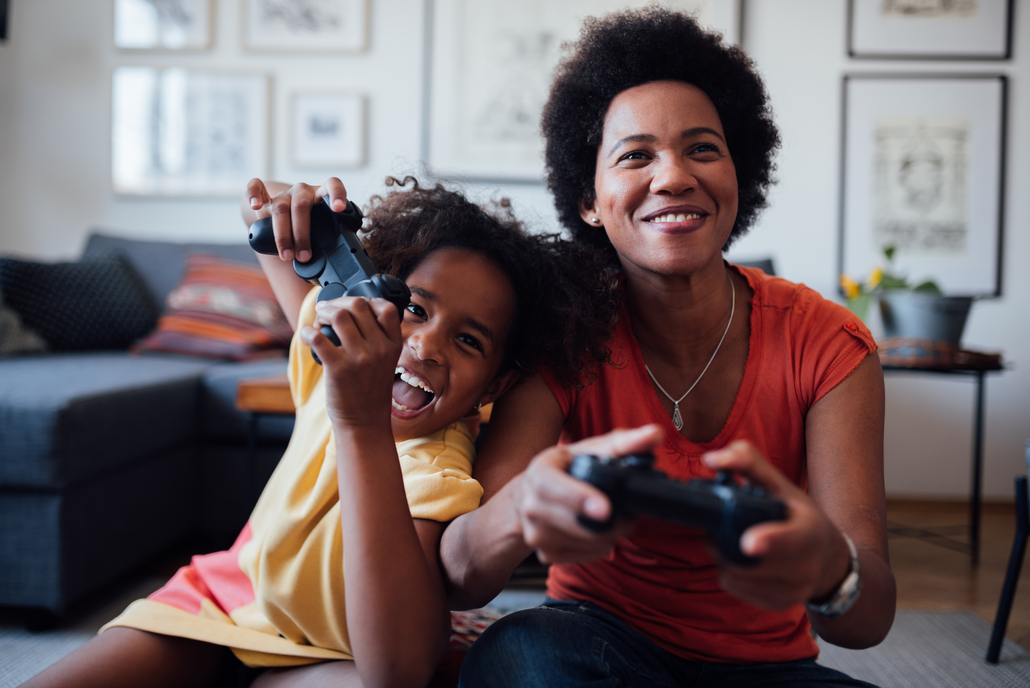 Front view of a mother and daughter playing video games together