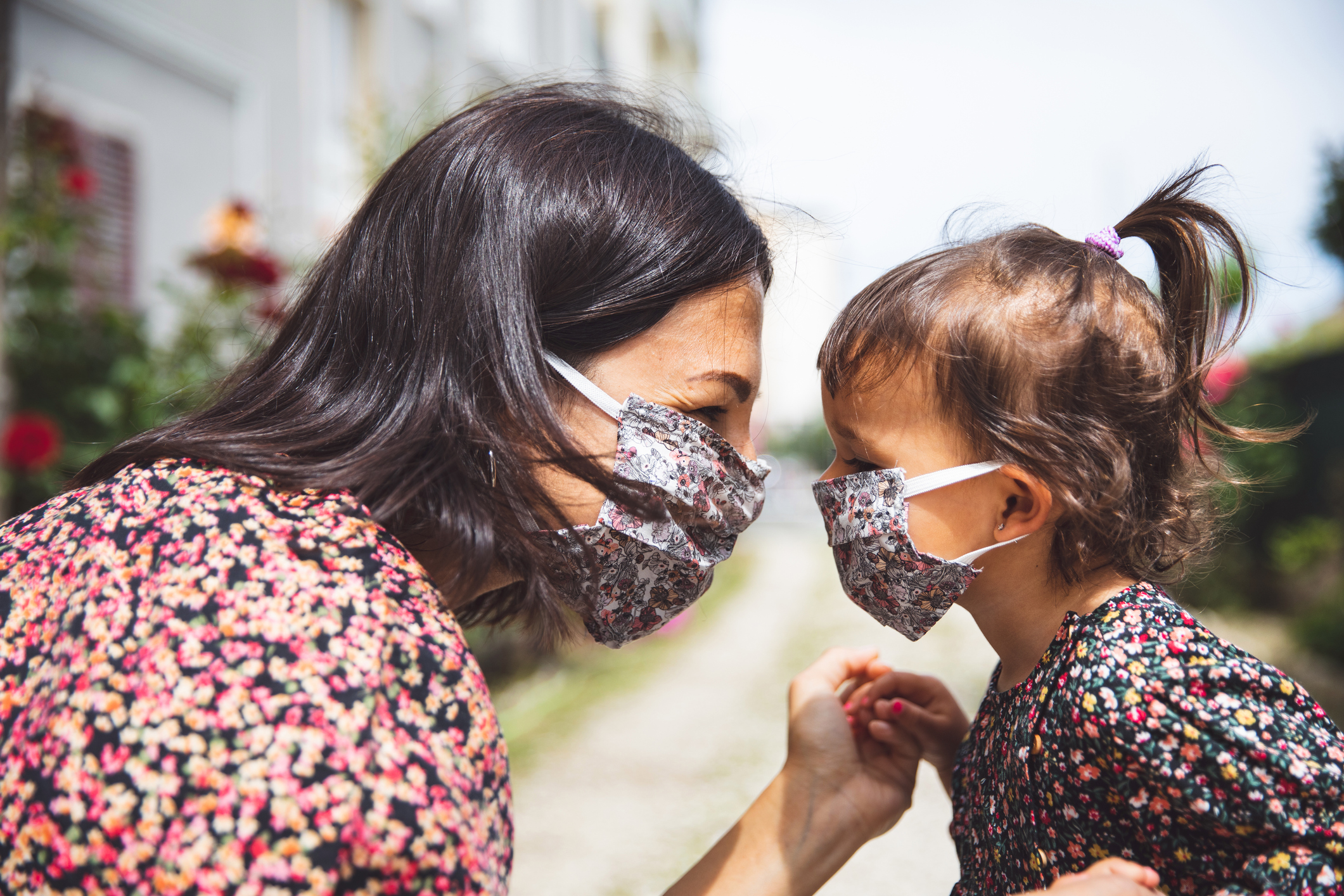 Portrait of a mother with her little daughter wearing surgical mask