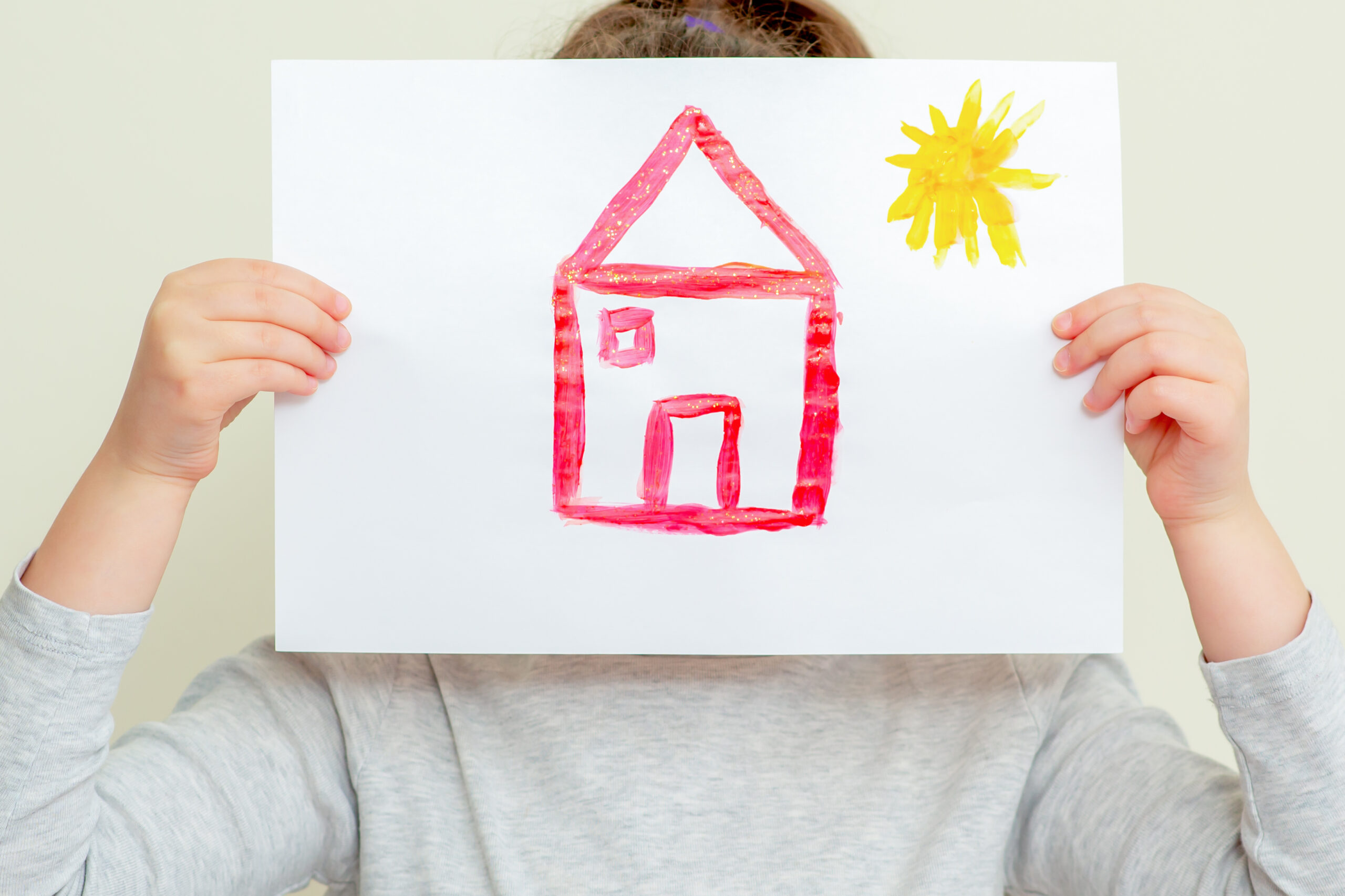 Child holding picture of house.