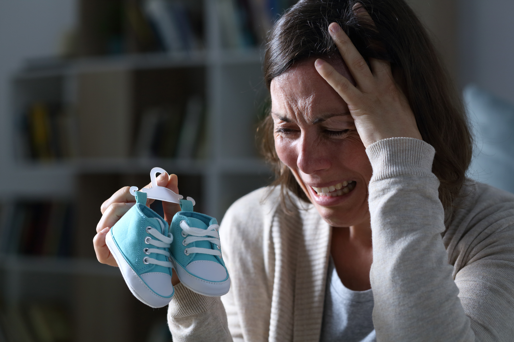 Sad mother missing her daughter after miscarriage at night at home