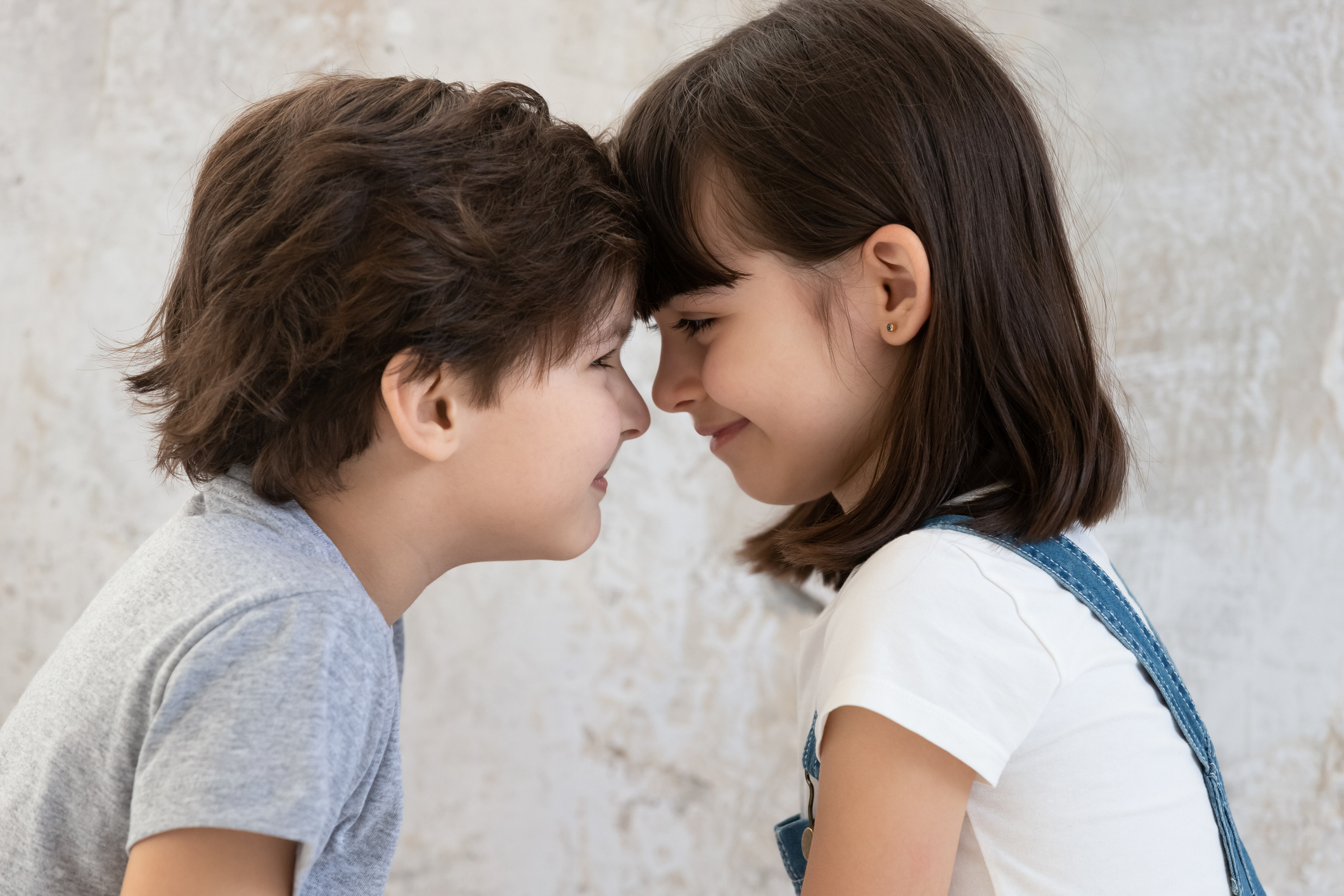 Close up of little siblings look in eyes showing love