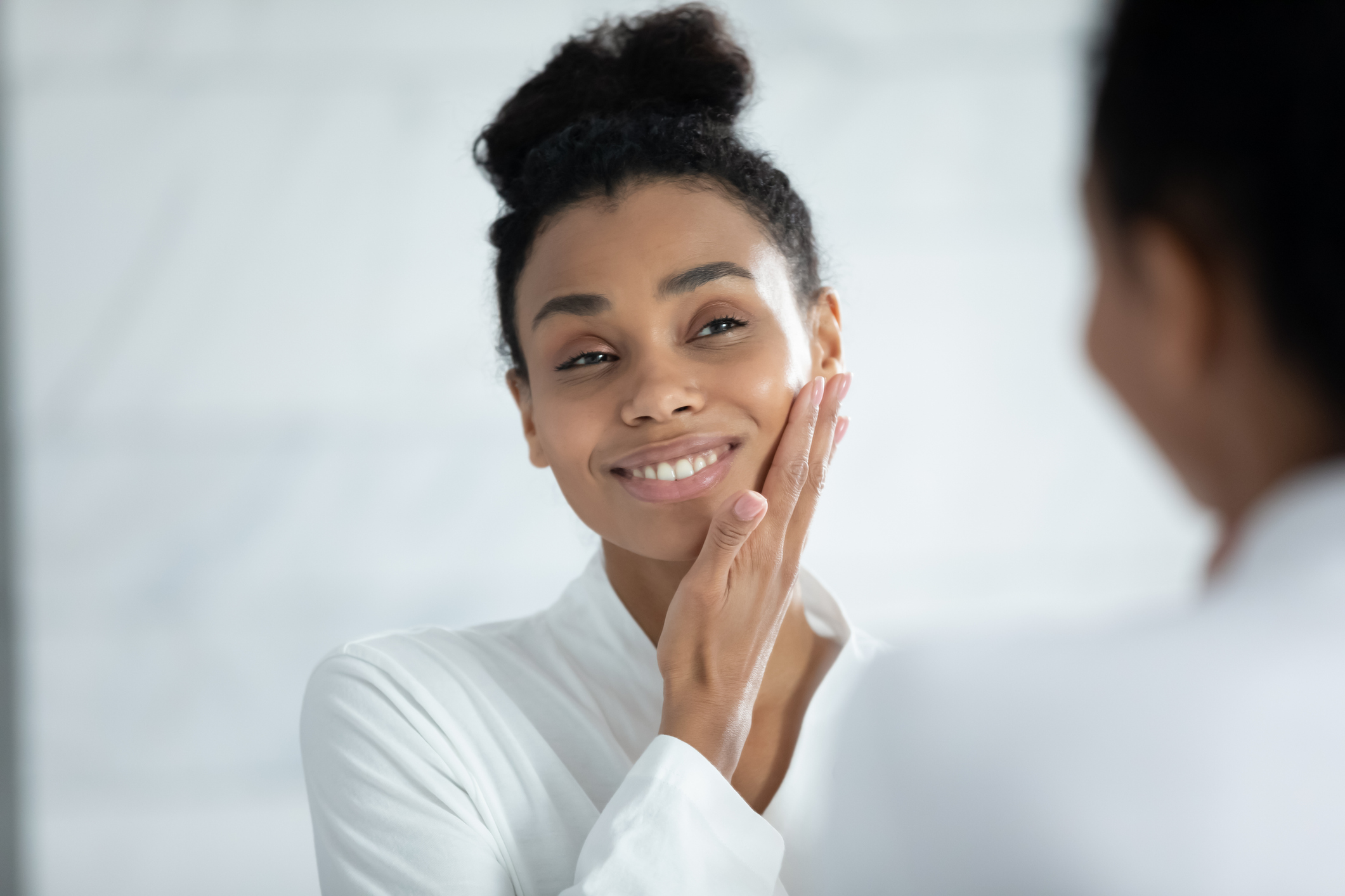 Head shot smiling African American woman touching smooth face skin