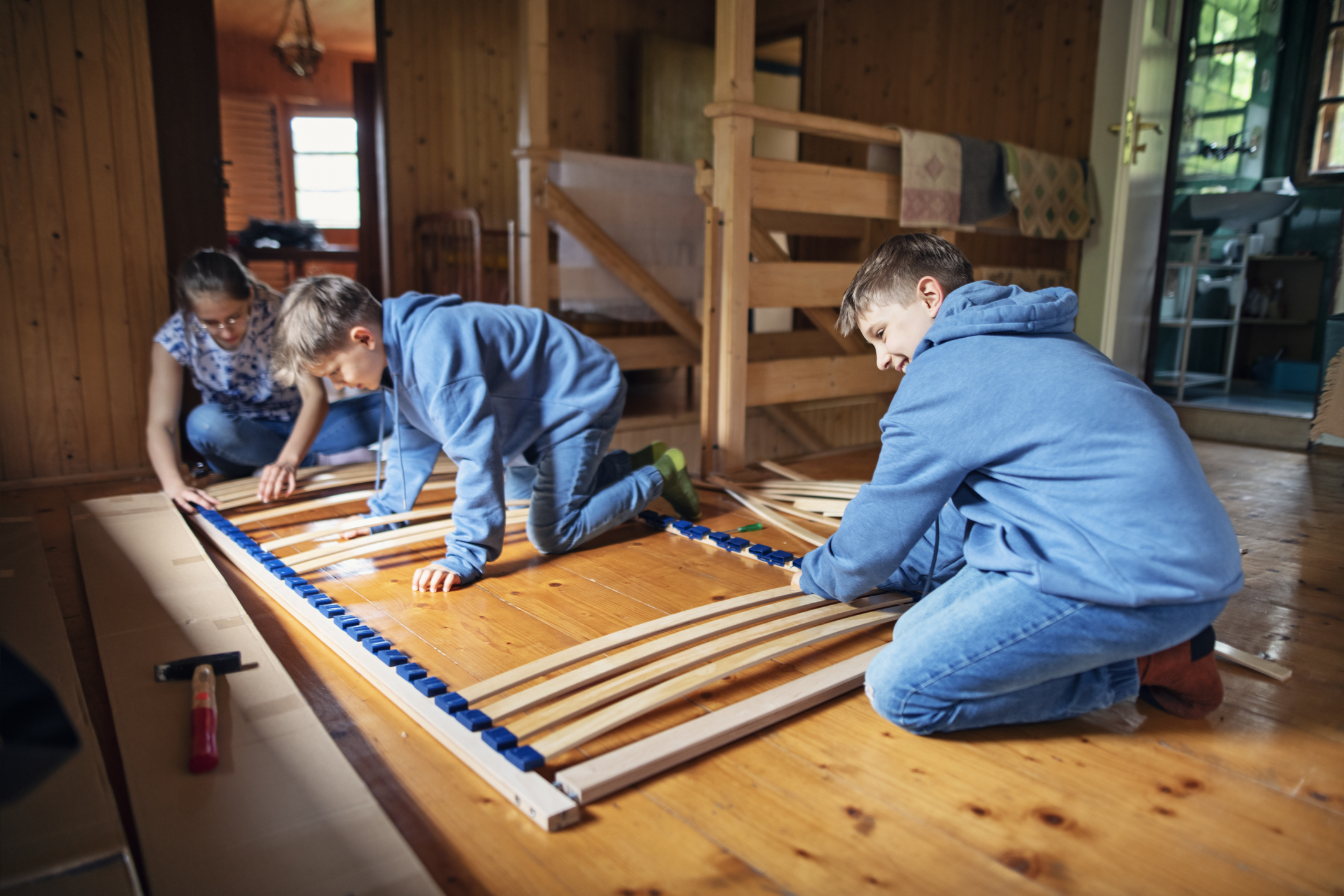 Kids assembling bed base at home