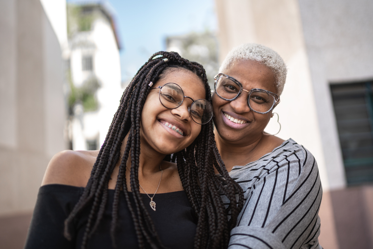 Portrait of mother and daughter embracing outside