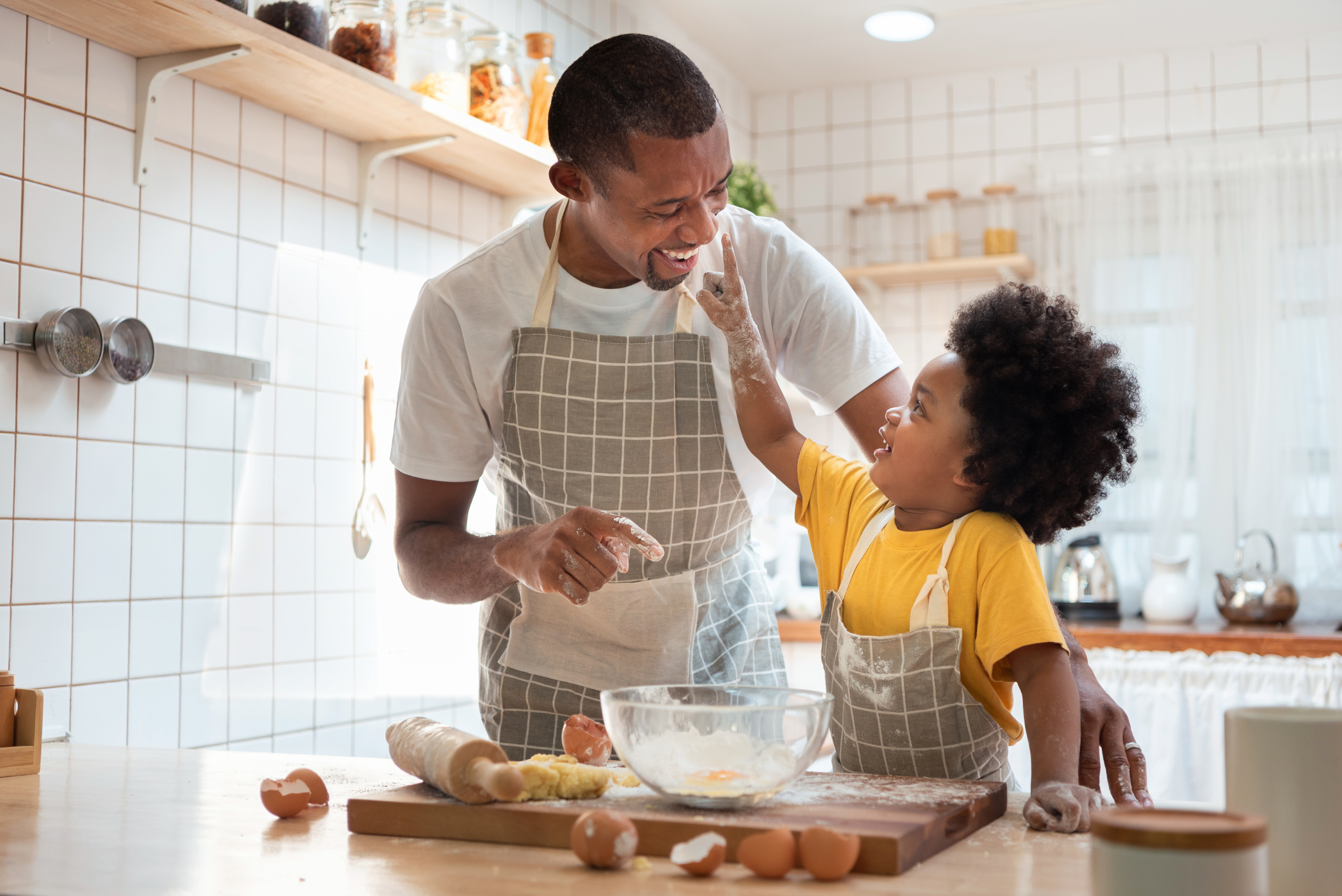 African Father and son enjoying during bake cookies at home together.