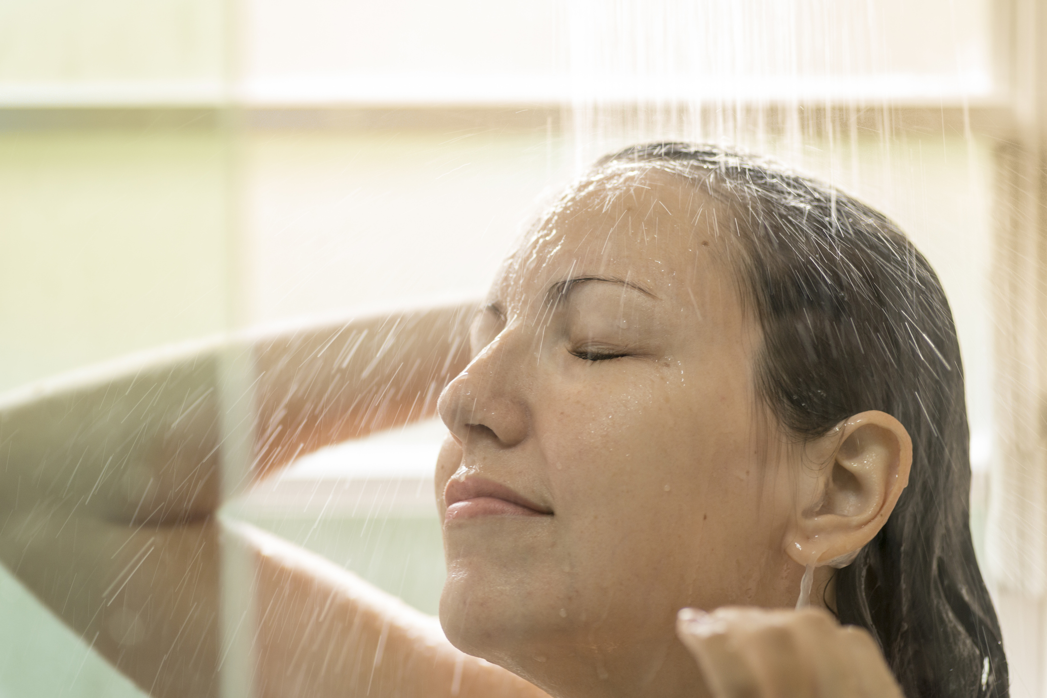 Woman showering and washing her wet hair