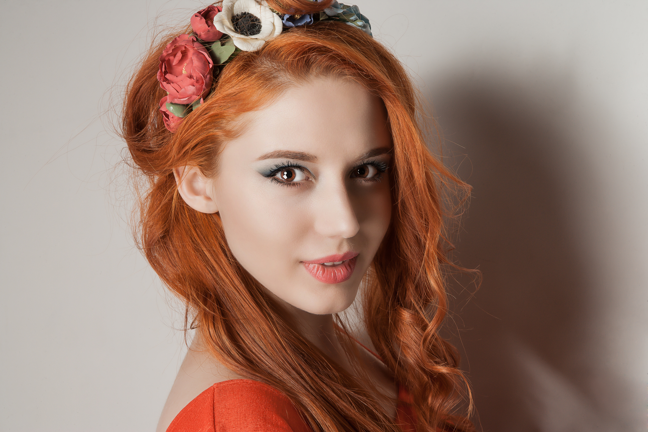 Happy young woman in a wreath of flowers