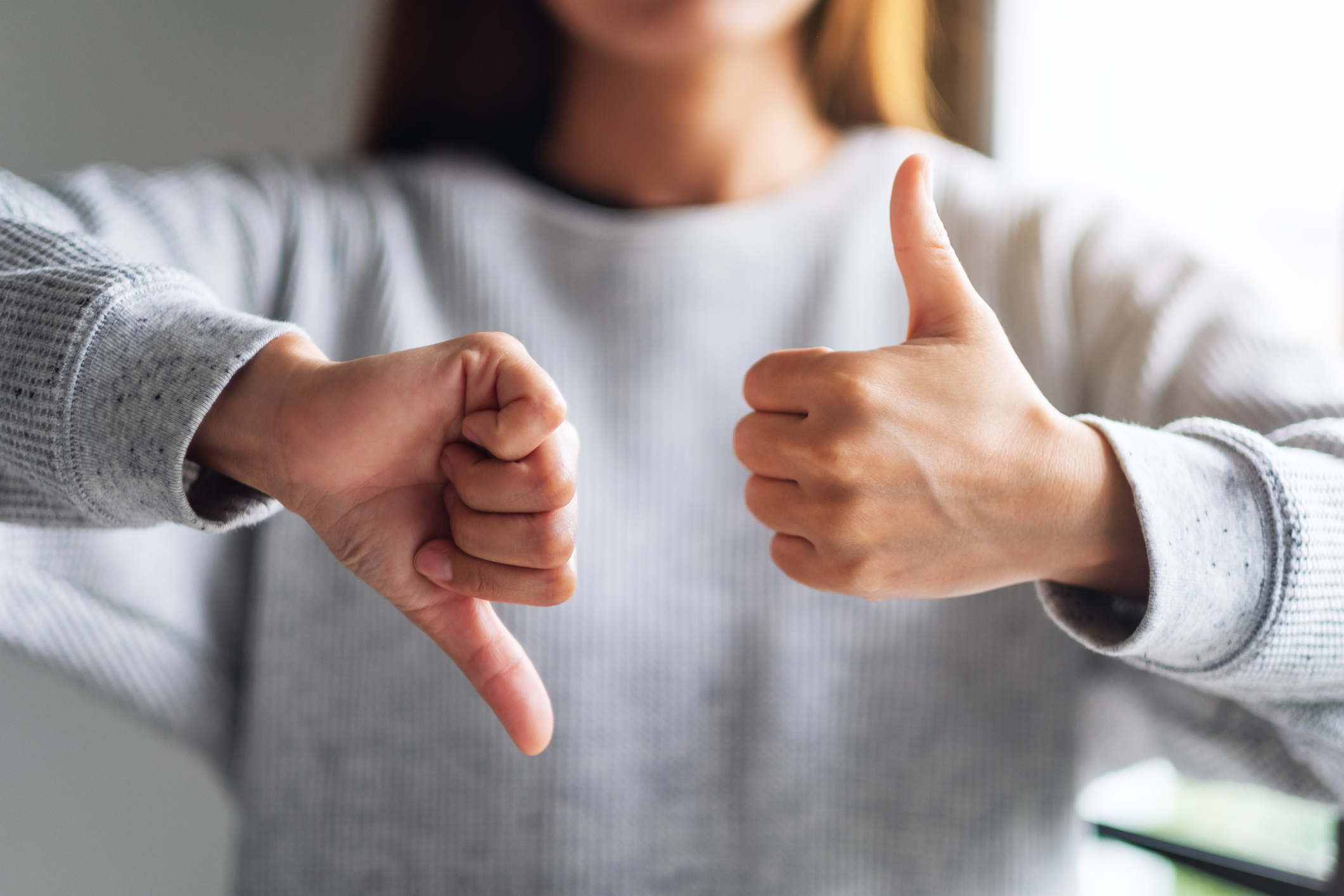 a woman making thumbs up and thumbs down hands sign