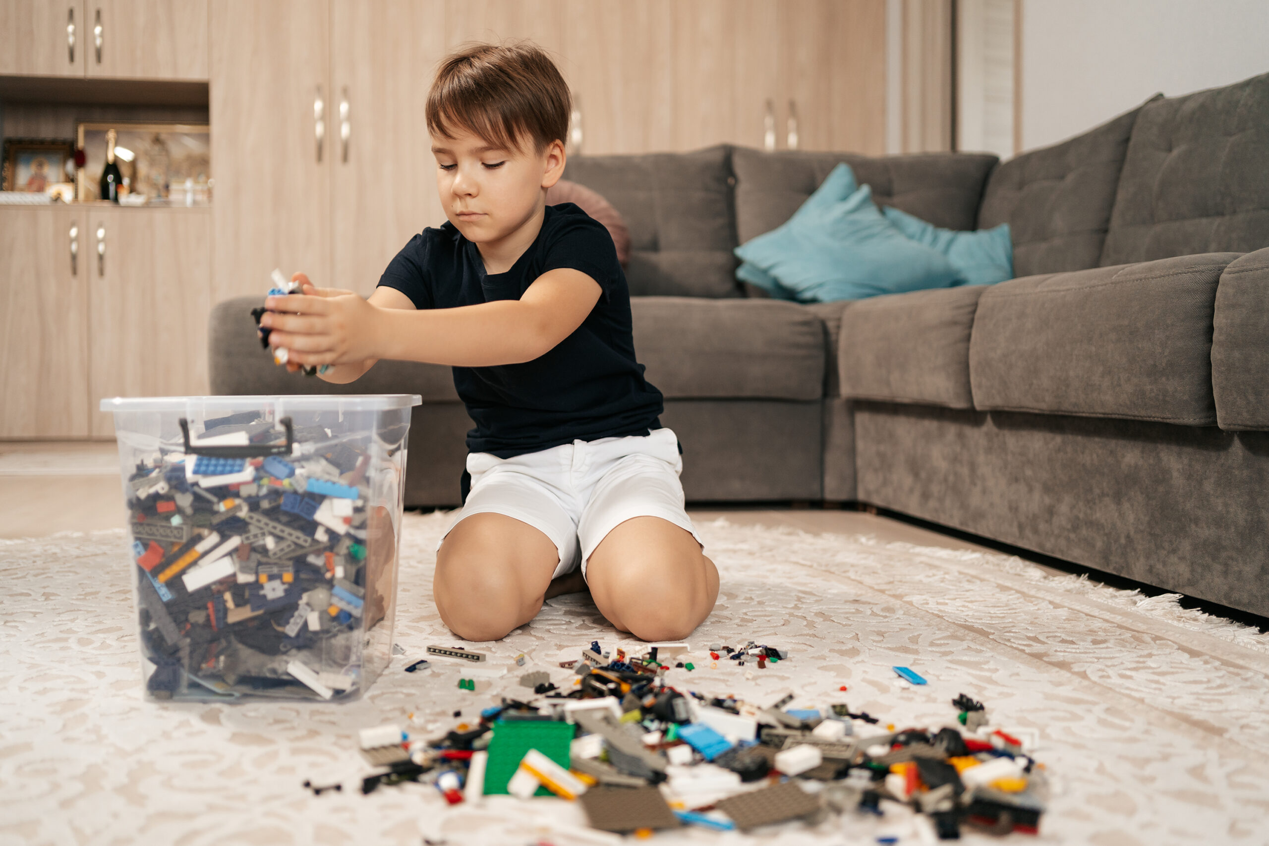 School boy playing plastic block at home