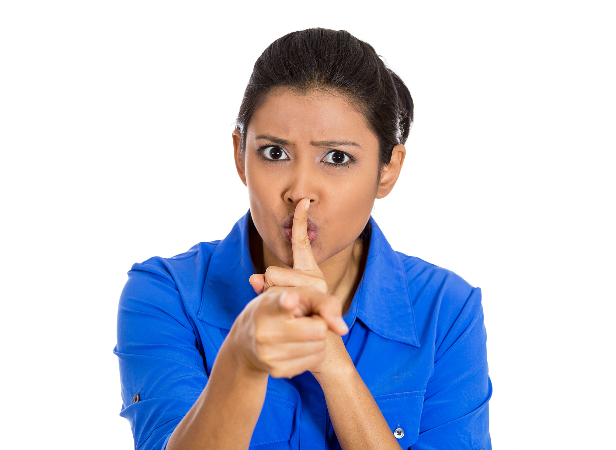 serious woman placing finger on lips, pointing at you quiet, silence