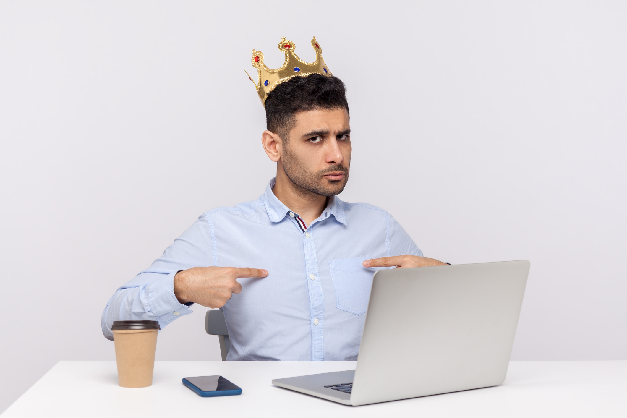 I'm big boss here! Proud authoritative businessman with crown on head sitting in office workplace, pointing himself