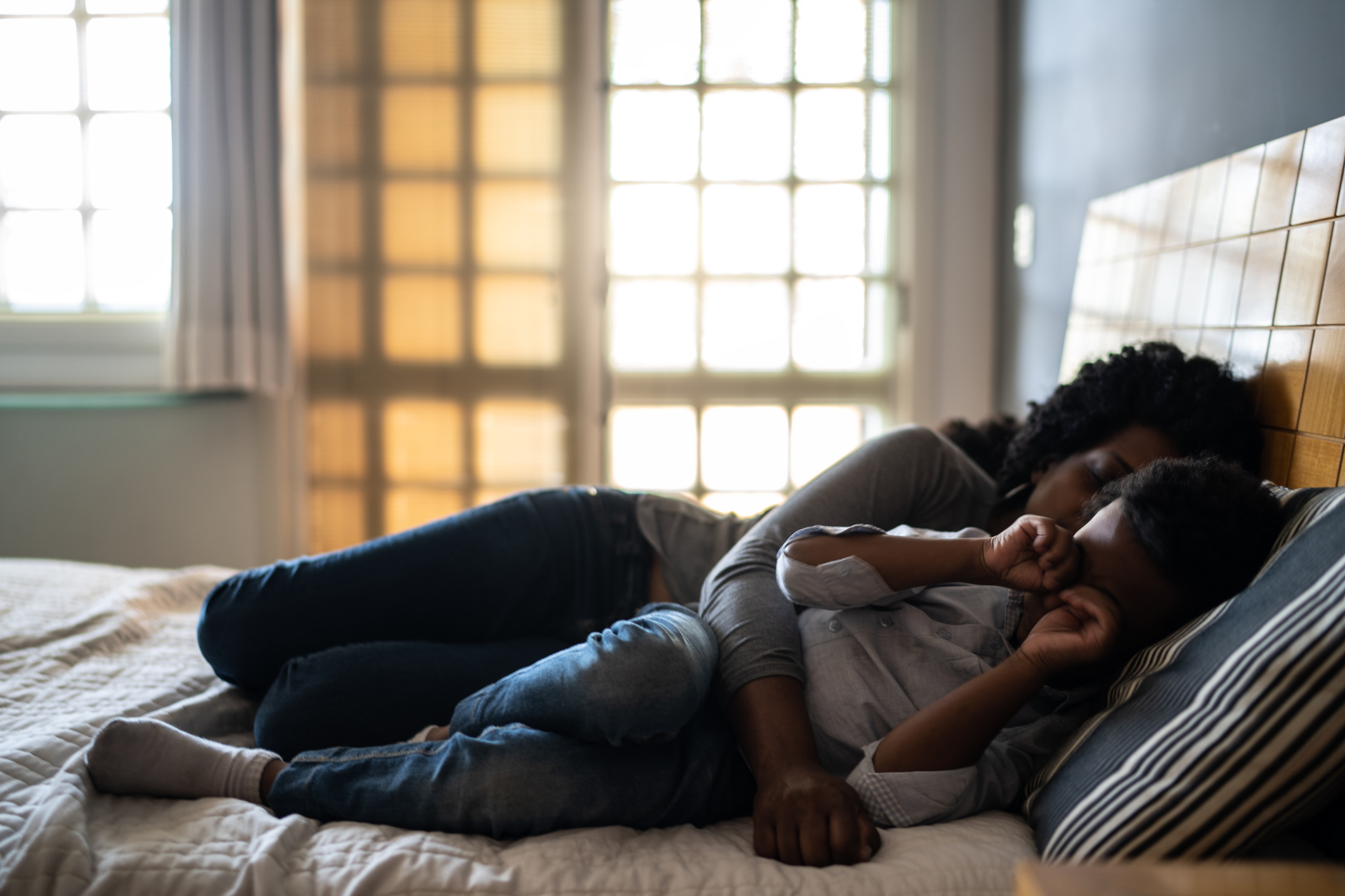 Child asleep next to mother at home