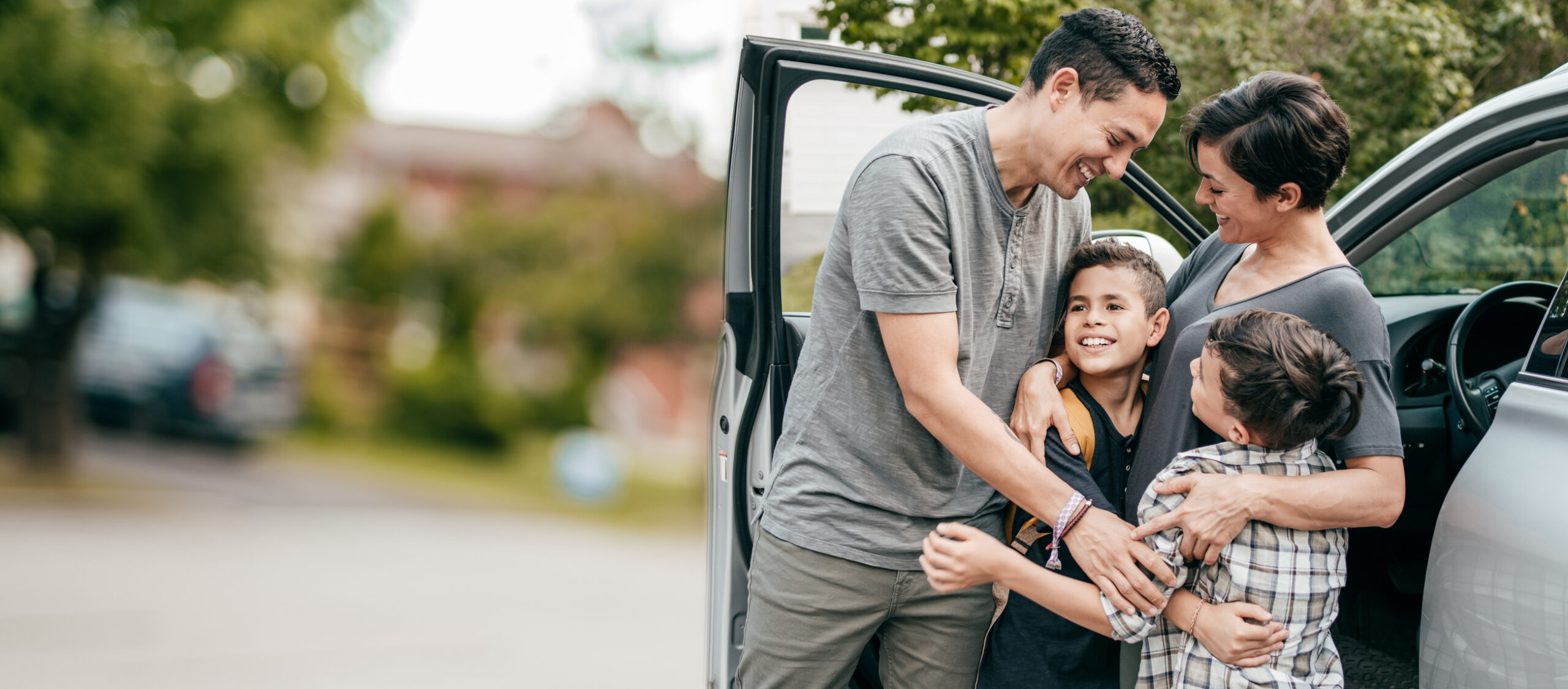 Family with two kids . Moment with hugs near car