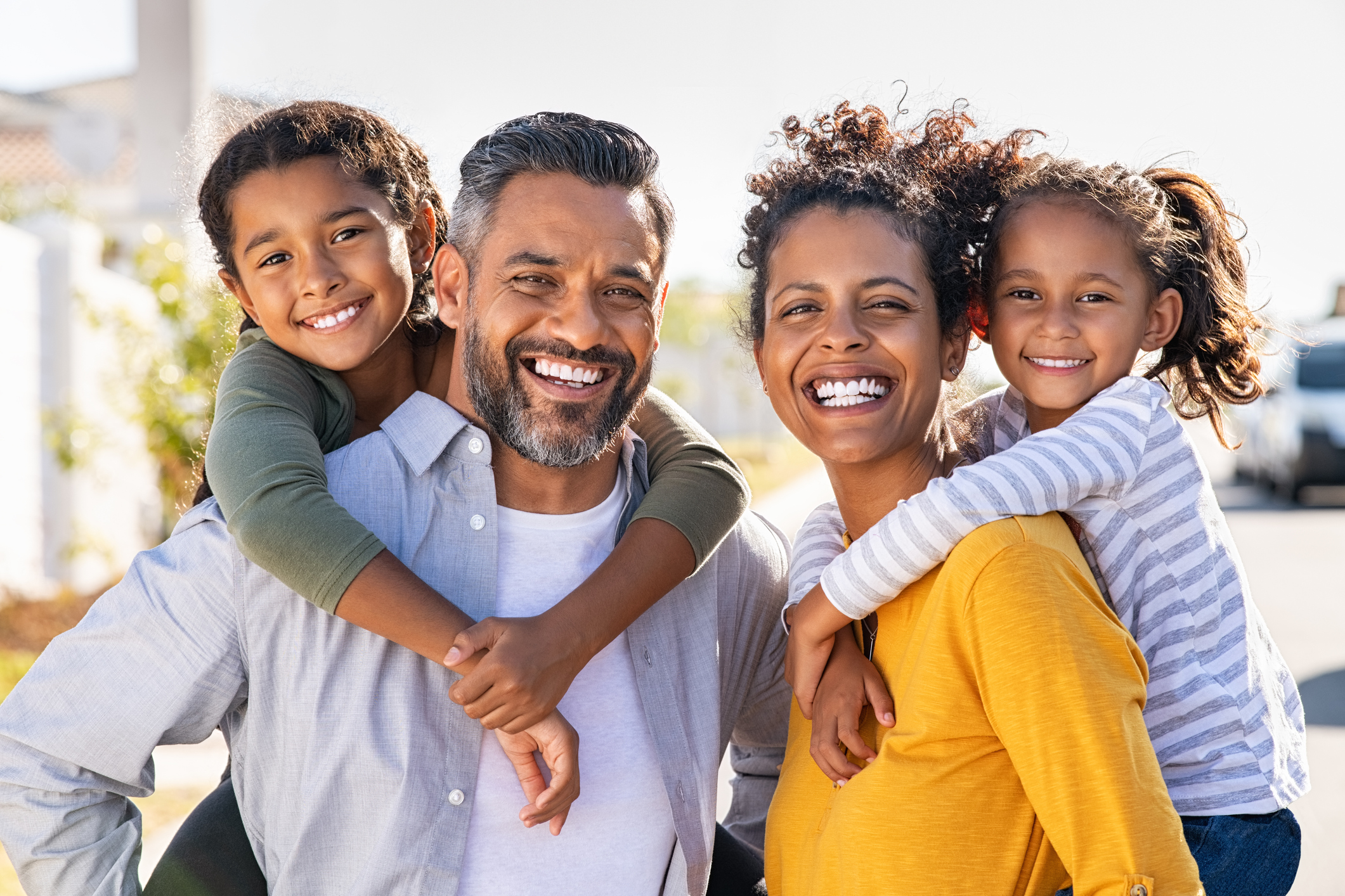 Multiethnic parents giving children piggyback ride