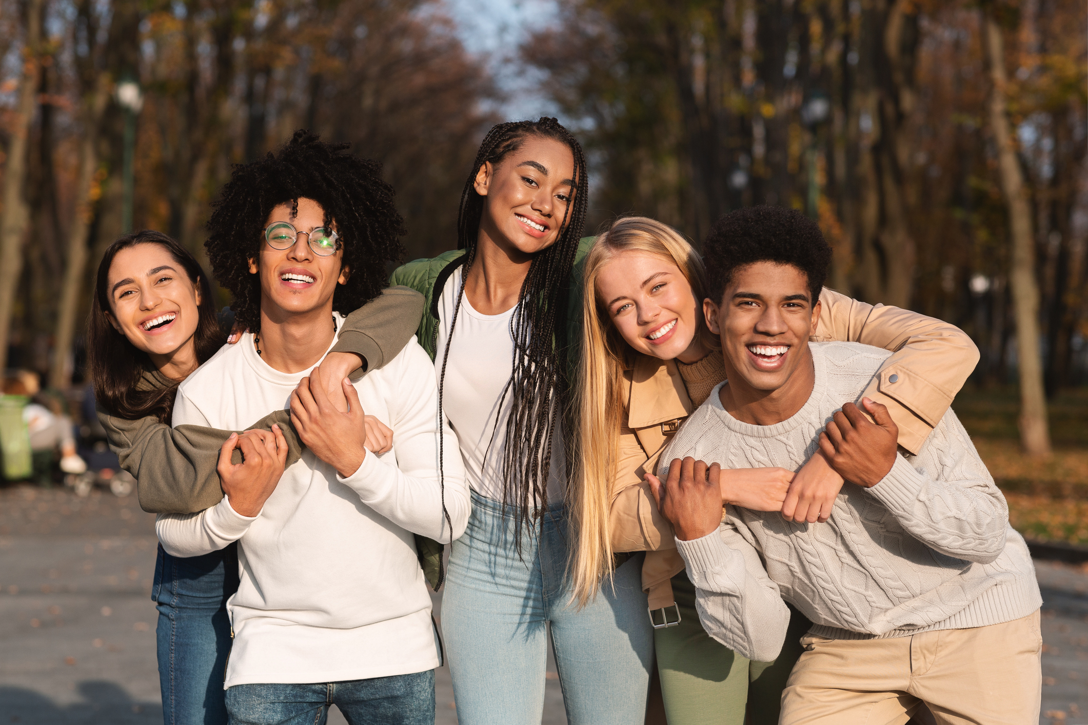 Positive group of young friends having fun at public park