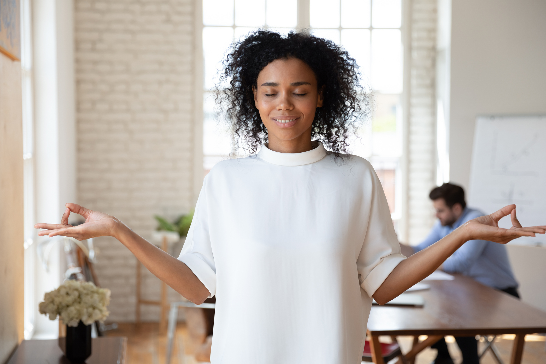 Calm biracial woman meditate practice yoga in office