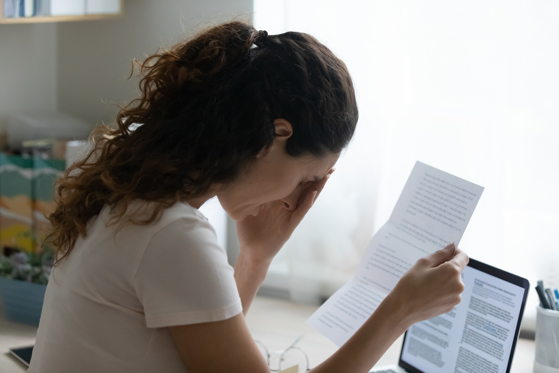 Unhappy woman stressed by bad news in letter correspondence