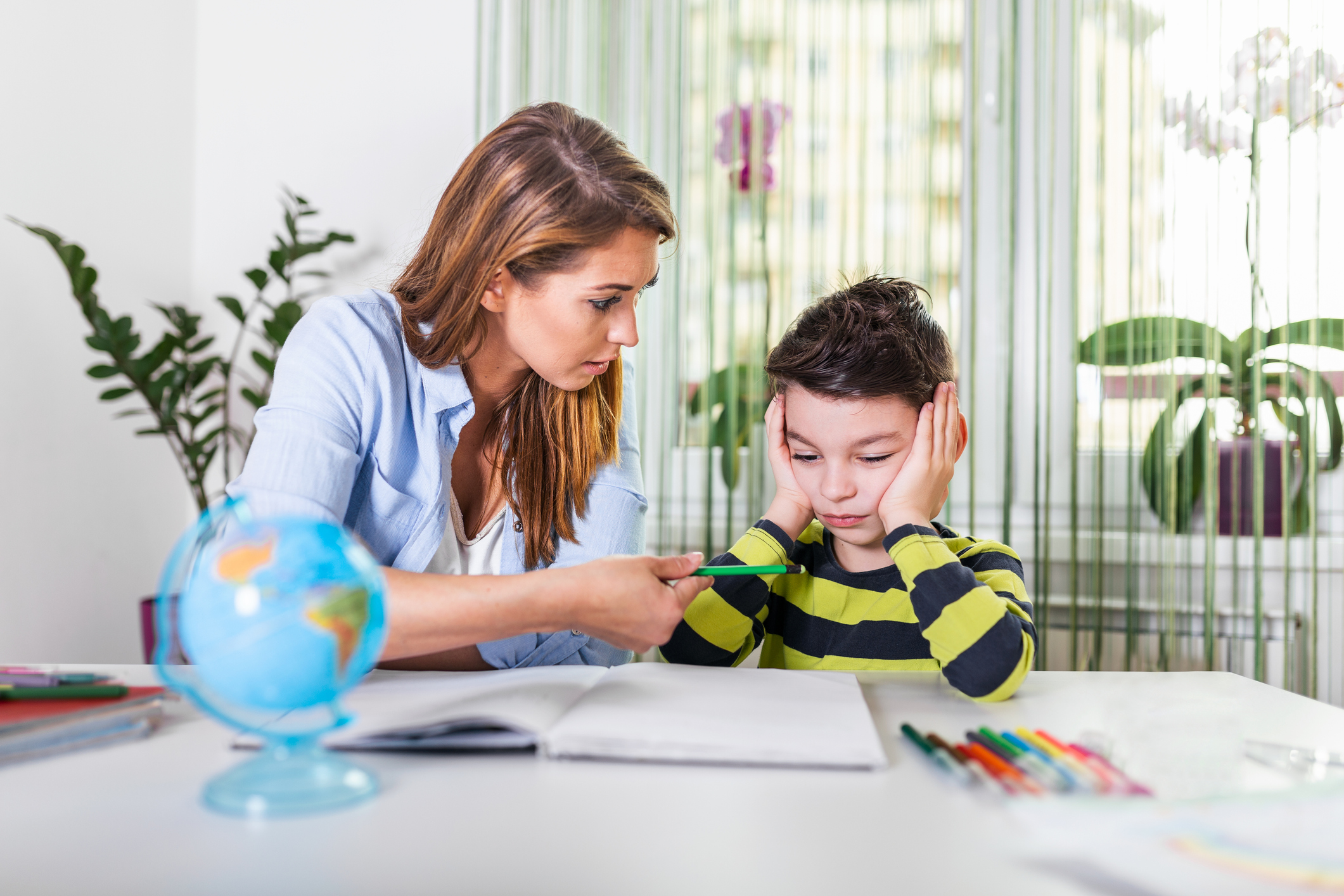 Mother Becoming Frustrated With Son Whilst Doing Homework. Mom makes the best teacher ever. Mother scolds a child for poor schooling and homework at home