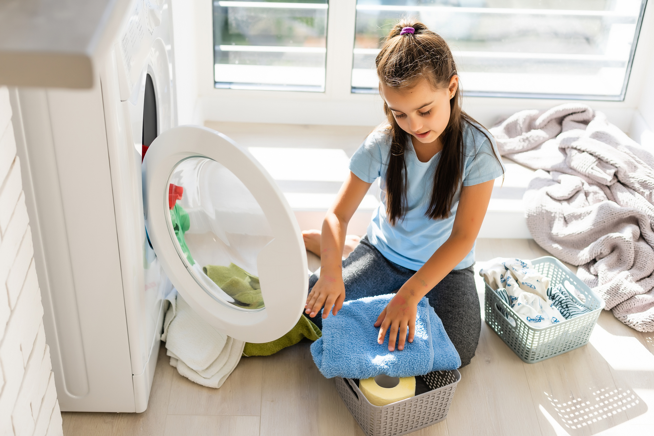 Little girl doing laundry. Housework concept.