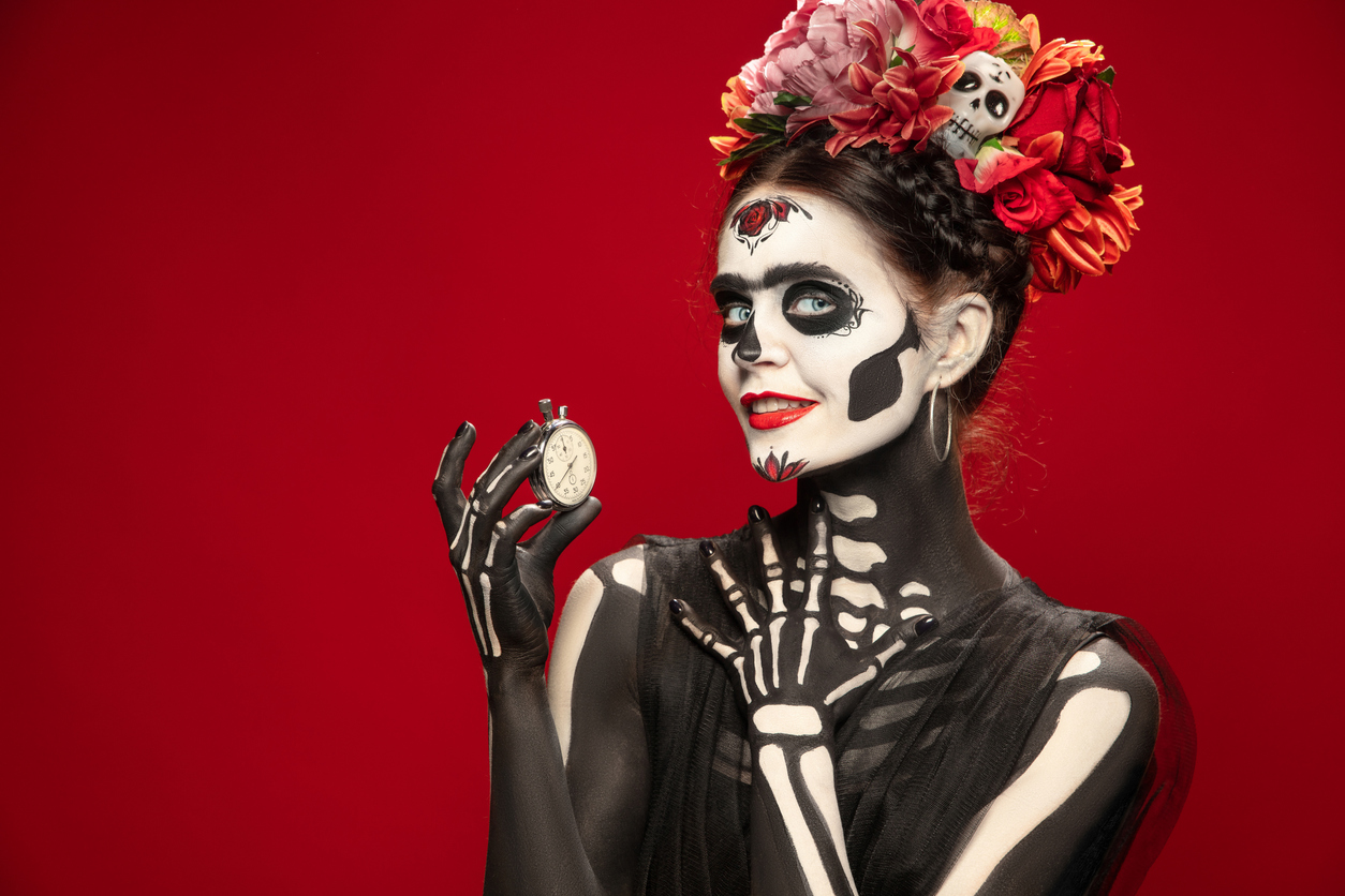 Young girl in the image of Santa Muerte, Saint death or Sugar skull with bright make-up. Portrait isolated on studio background.