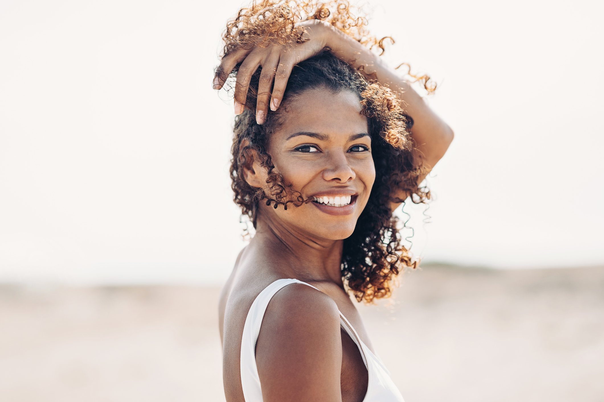 Beautiful young woman walking on the beach on a windy day