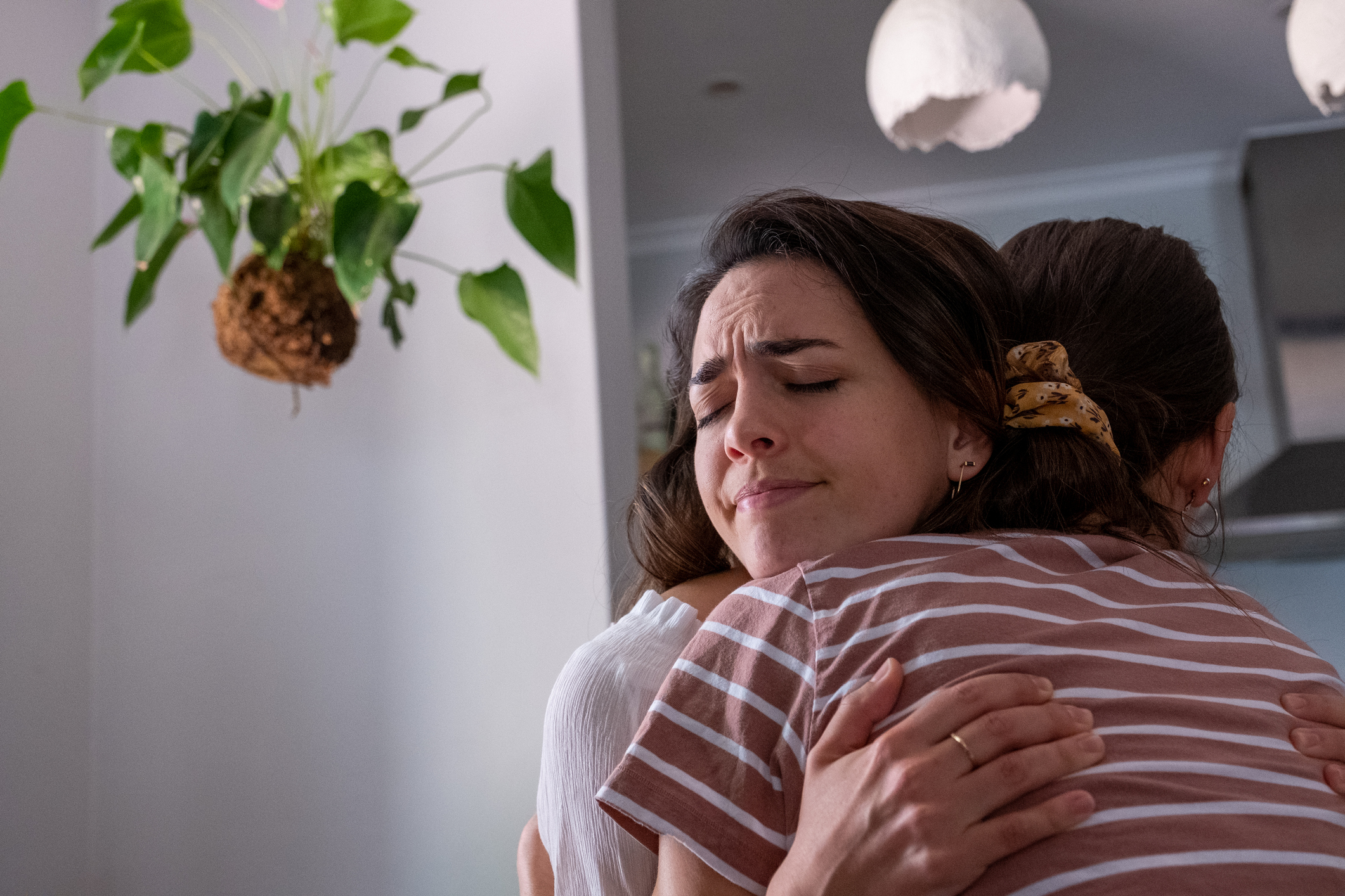 Young woman embraces her emotional friend