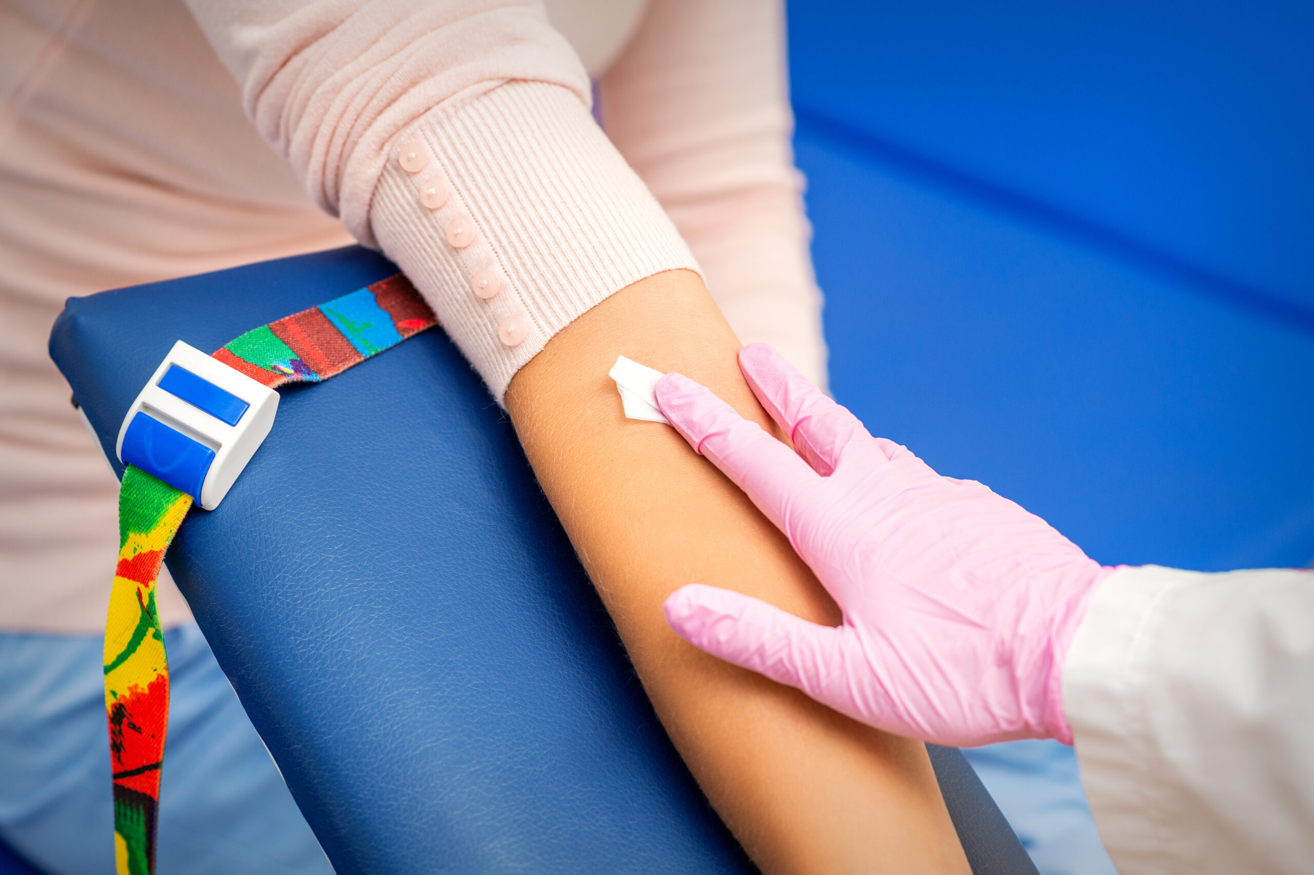 Nurse applying cotton swab to arm