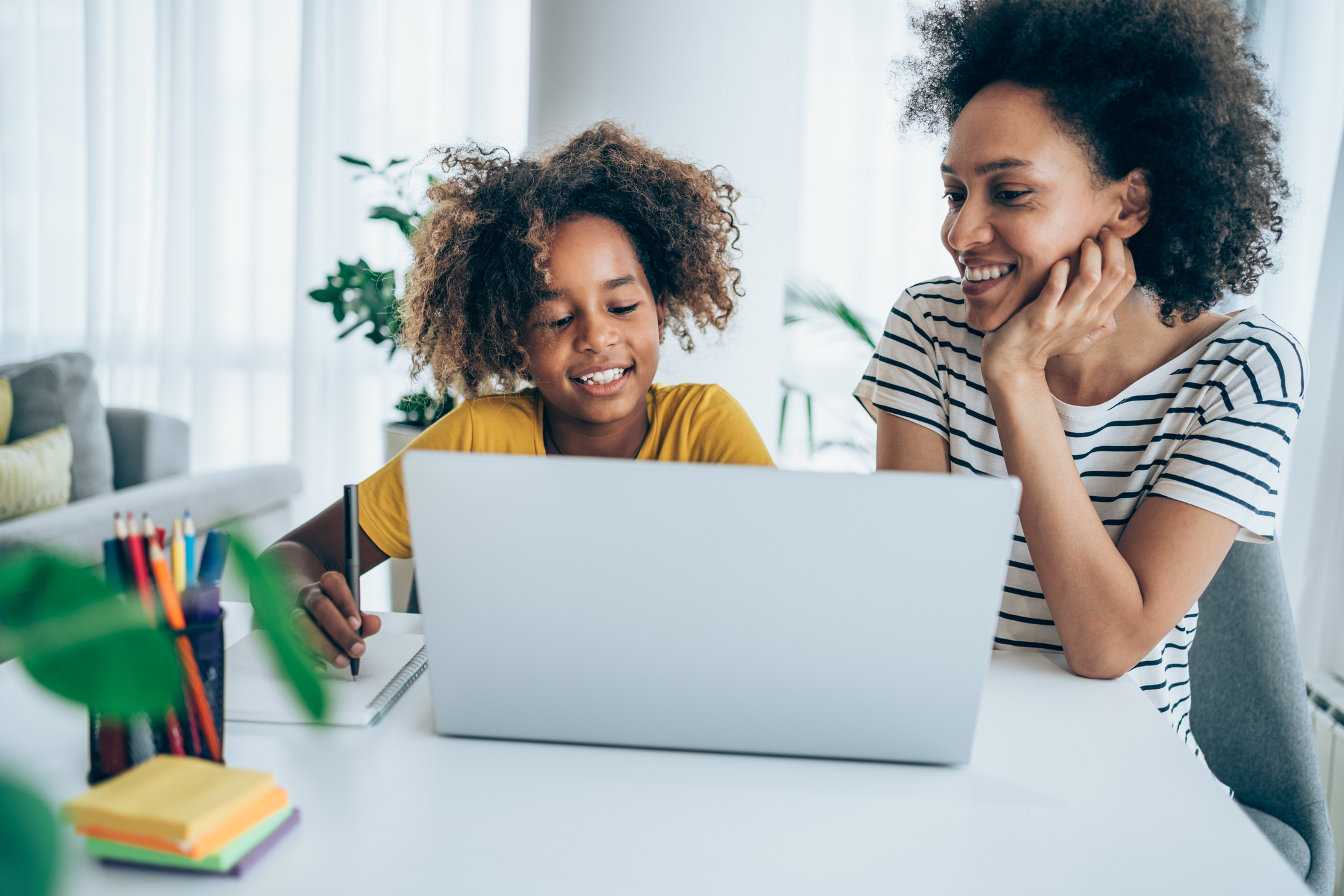 Mother and daughter studying online at home.