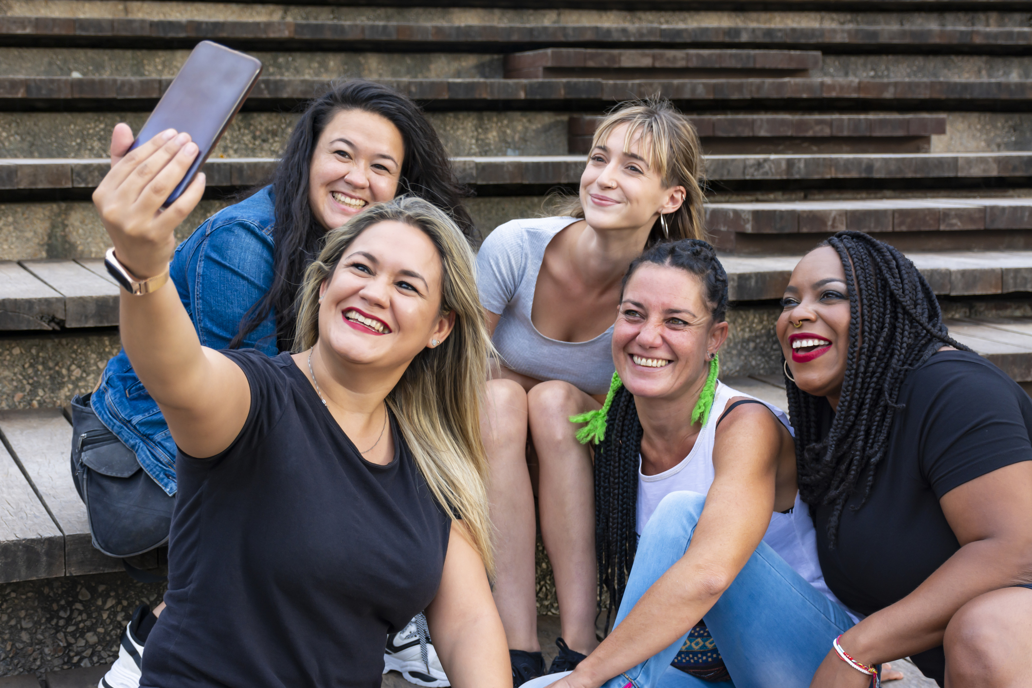 Five girls having fun with mobile phone