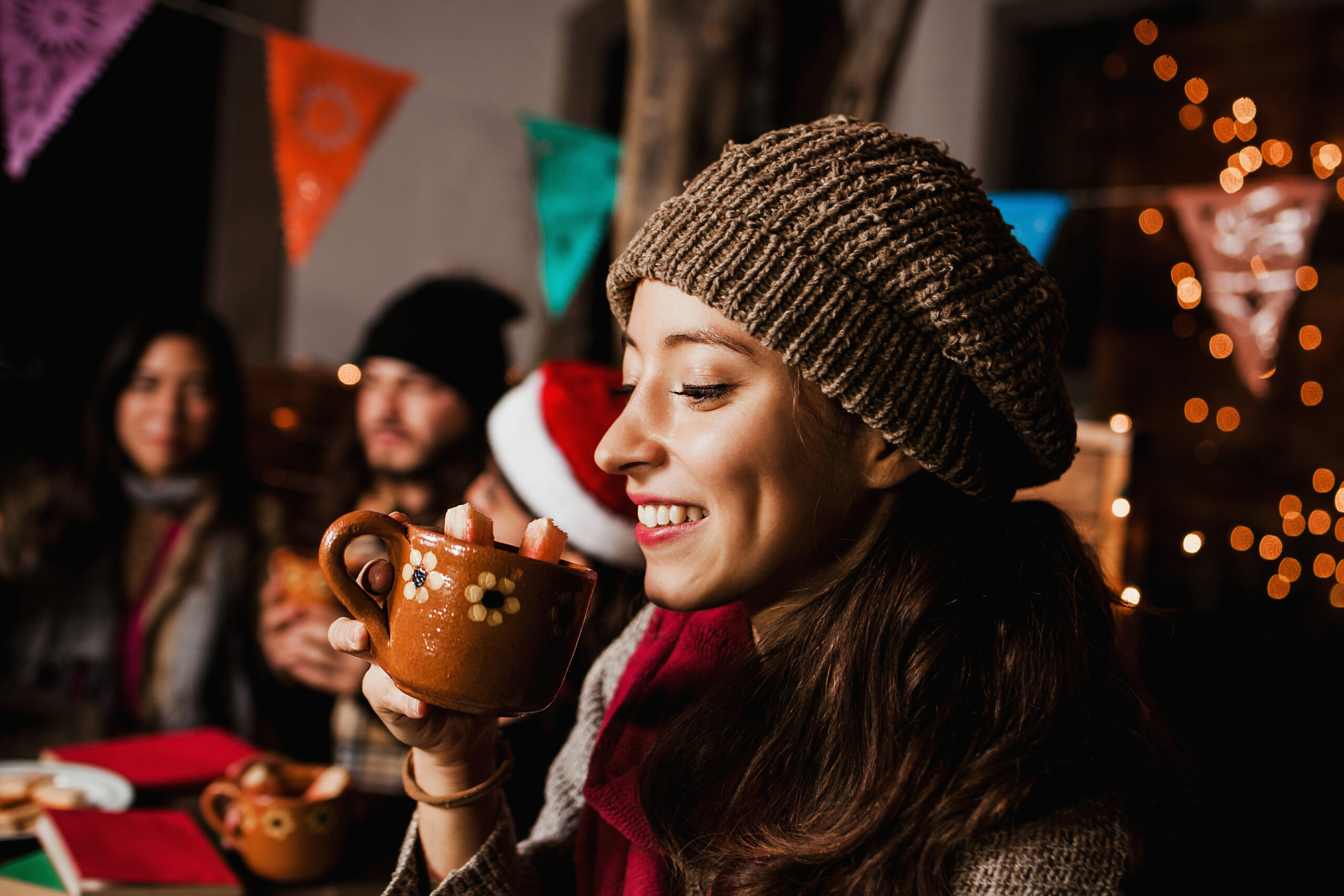 Mexican Woman drinking Christmas punch celebrating a Posada at Christmas party in Mexico