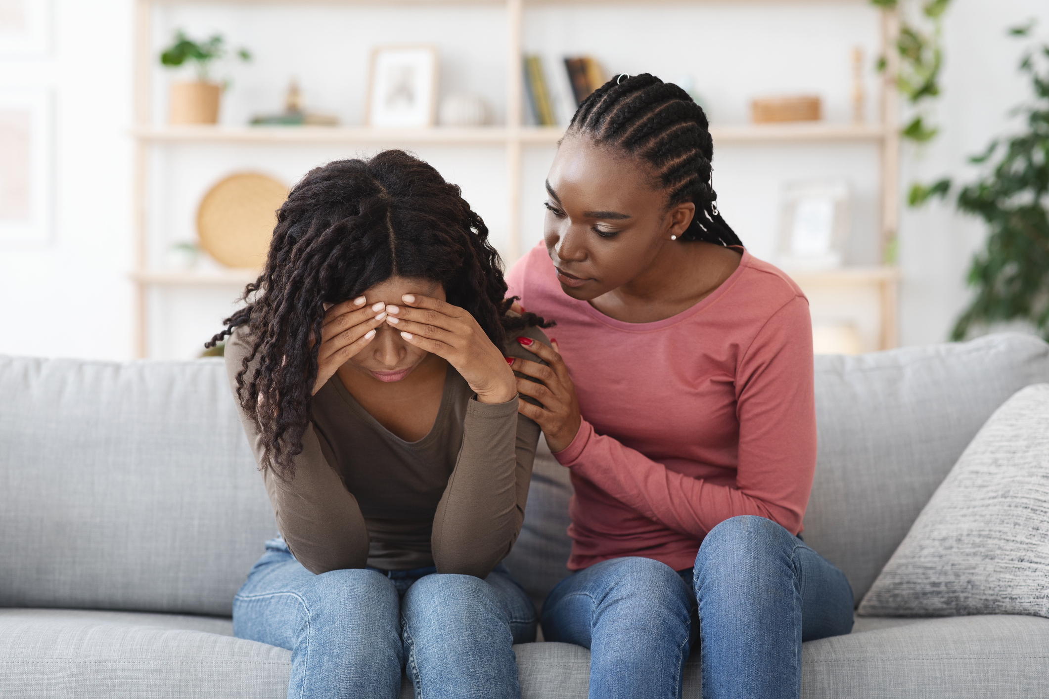 Attentive african american lady comforting her upset friend