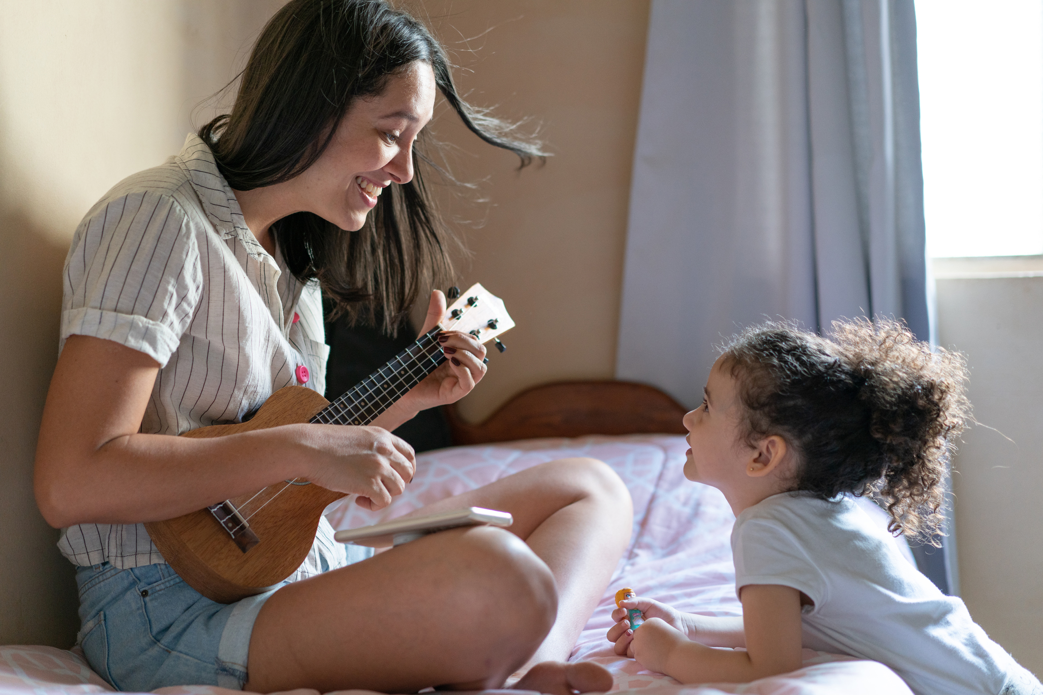 Aunt playing ukulele for niece