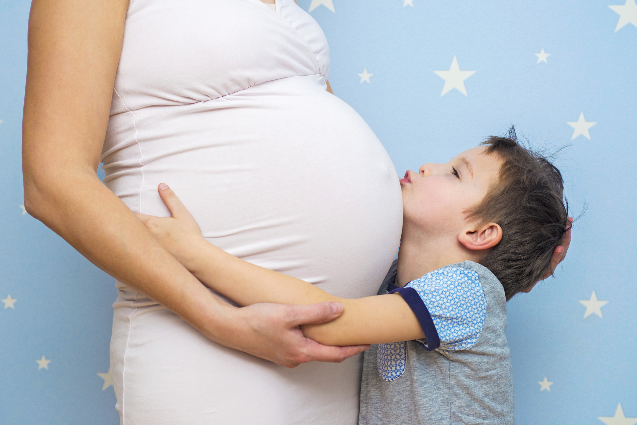 Kid boy hugging pregnant mother's belly. Happy kid boy hugging pregnant mother's belly, pregnancy. New life concept