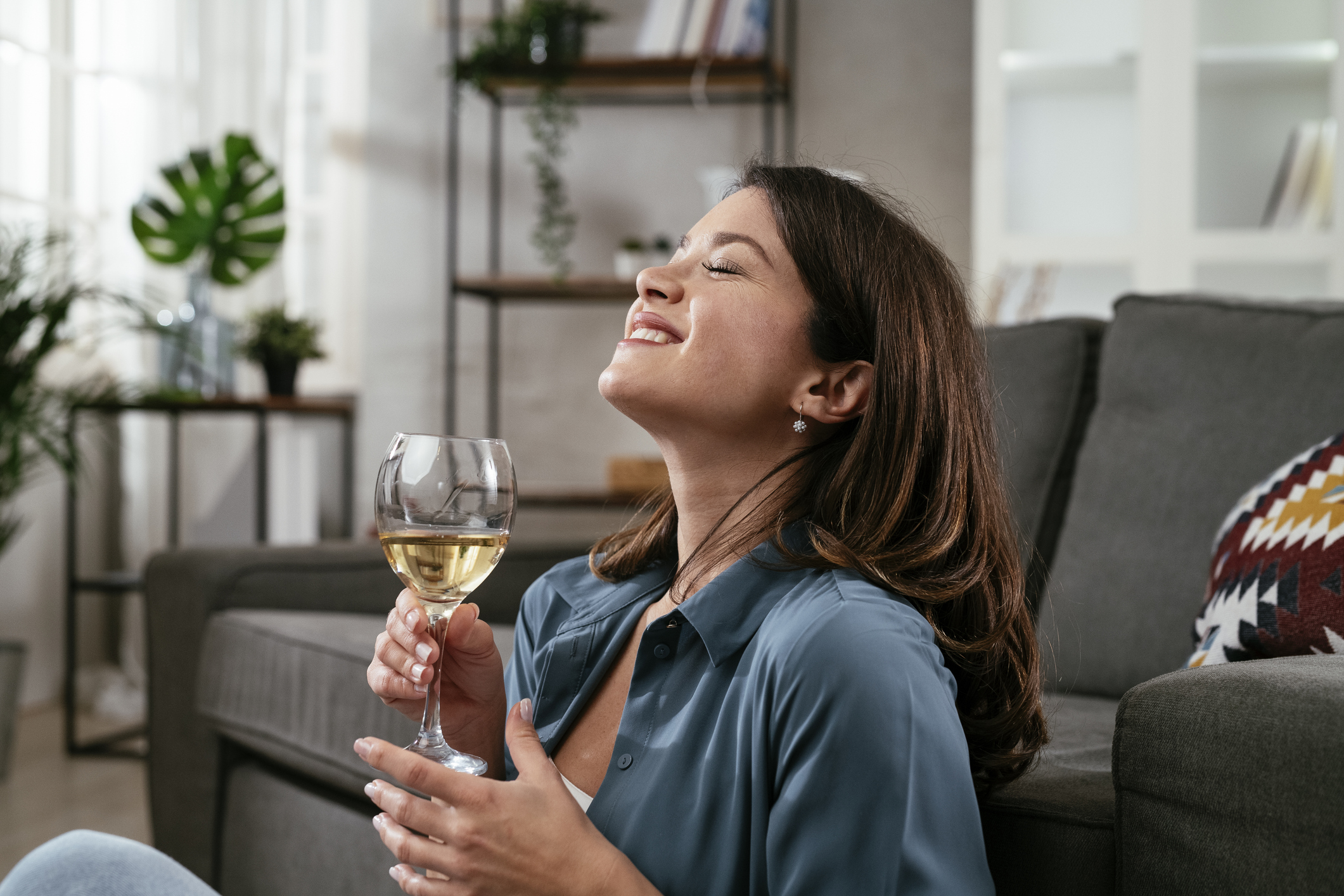 Beautiful woman sitting on the floor, drinking wine.