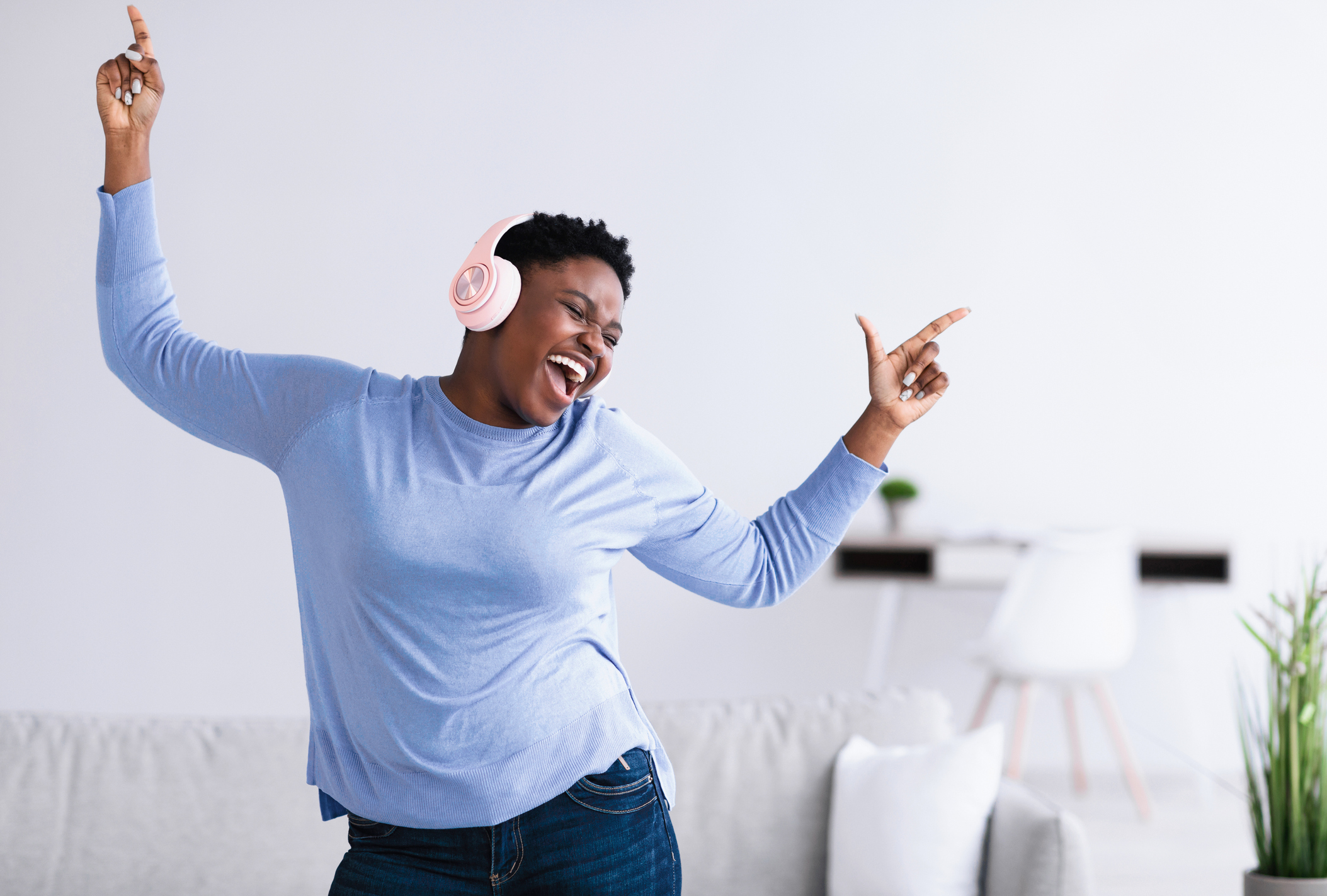 Black woman listening to music in headphones and dancing