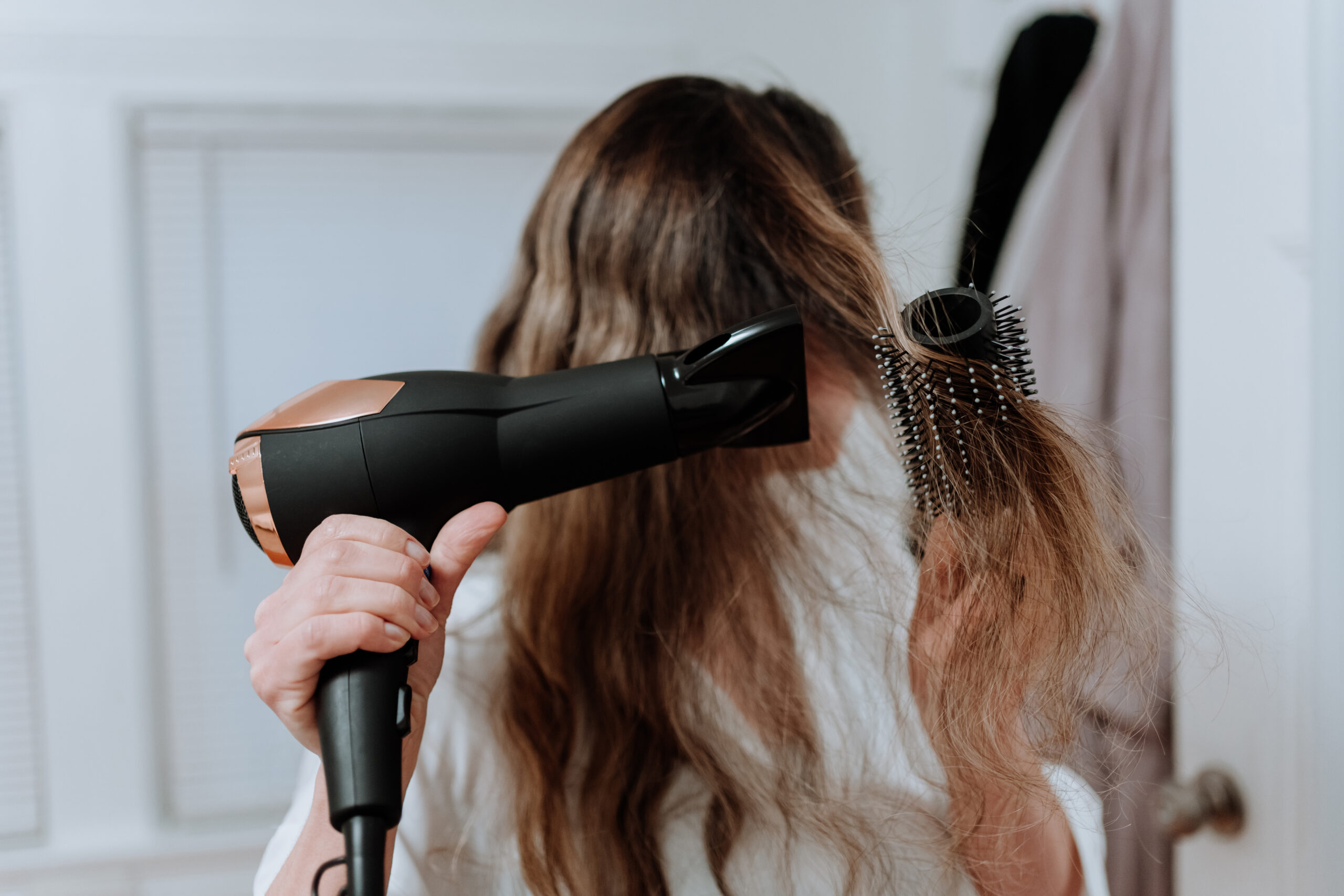 woman drying her hair with dryer