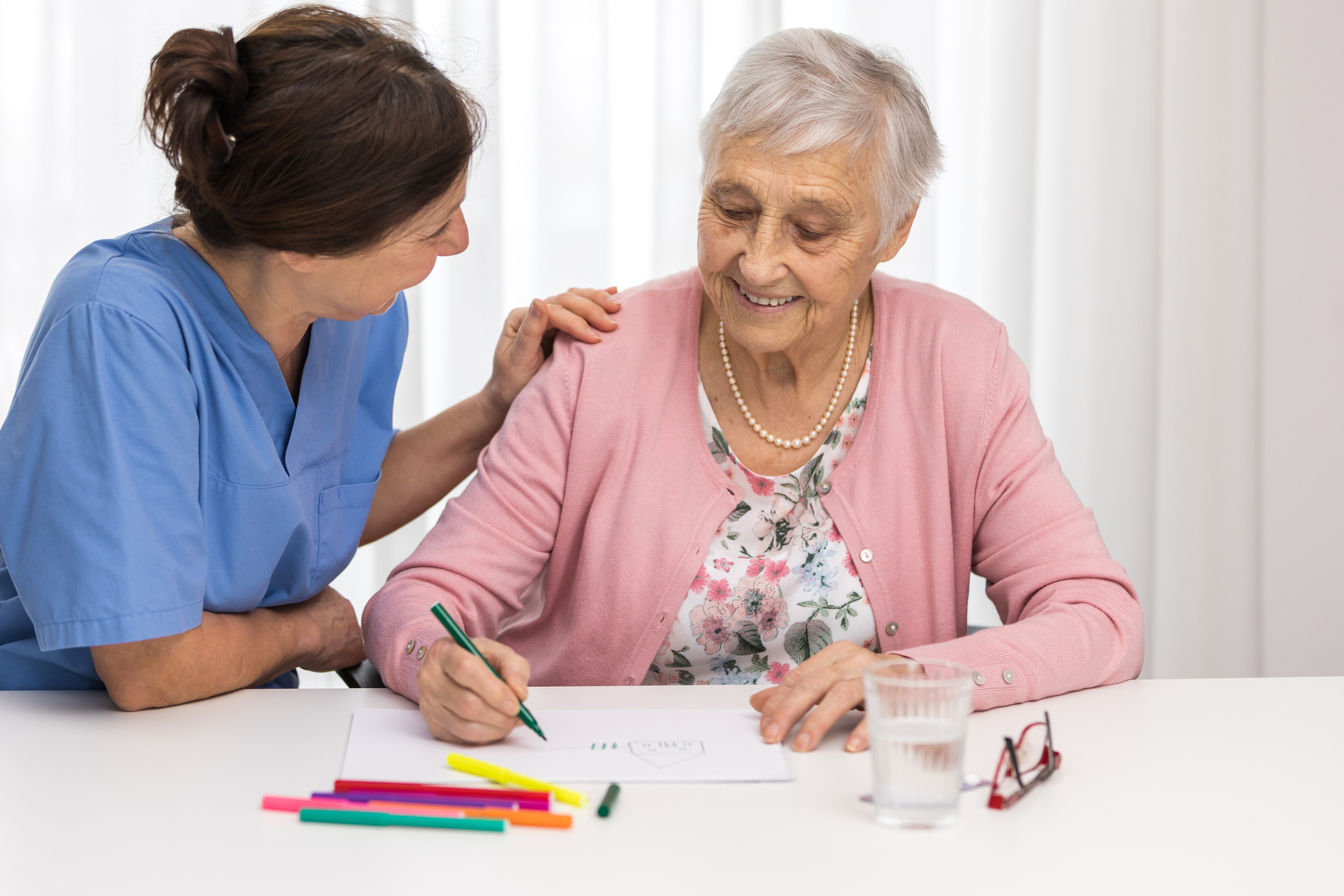 Nursing home therapy- senior woman drawing on white paper