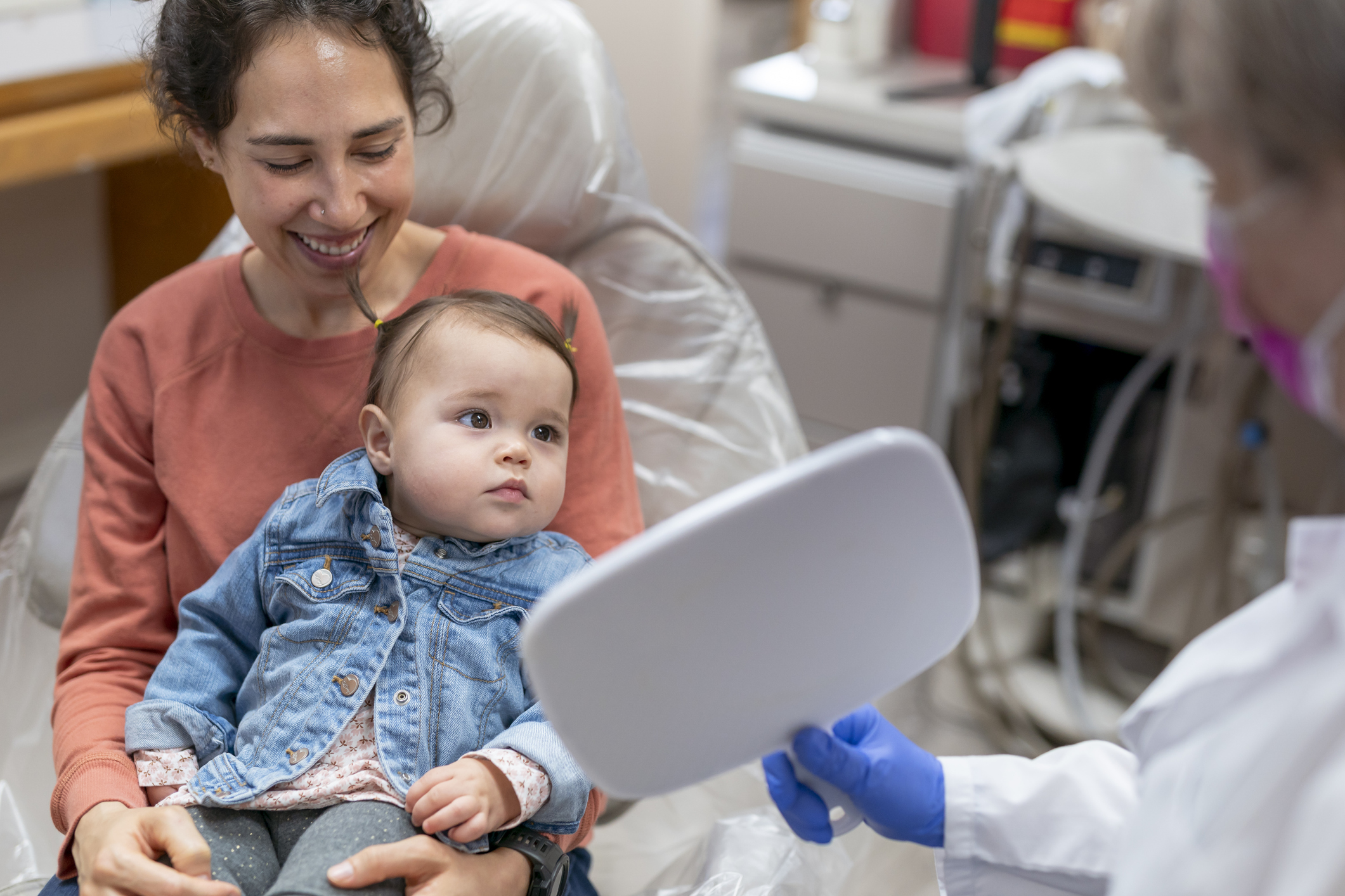 Mom and young daughter meeting with friendly dentist