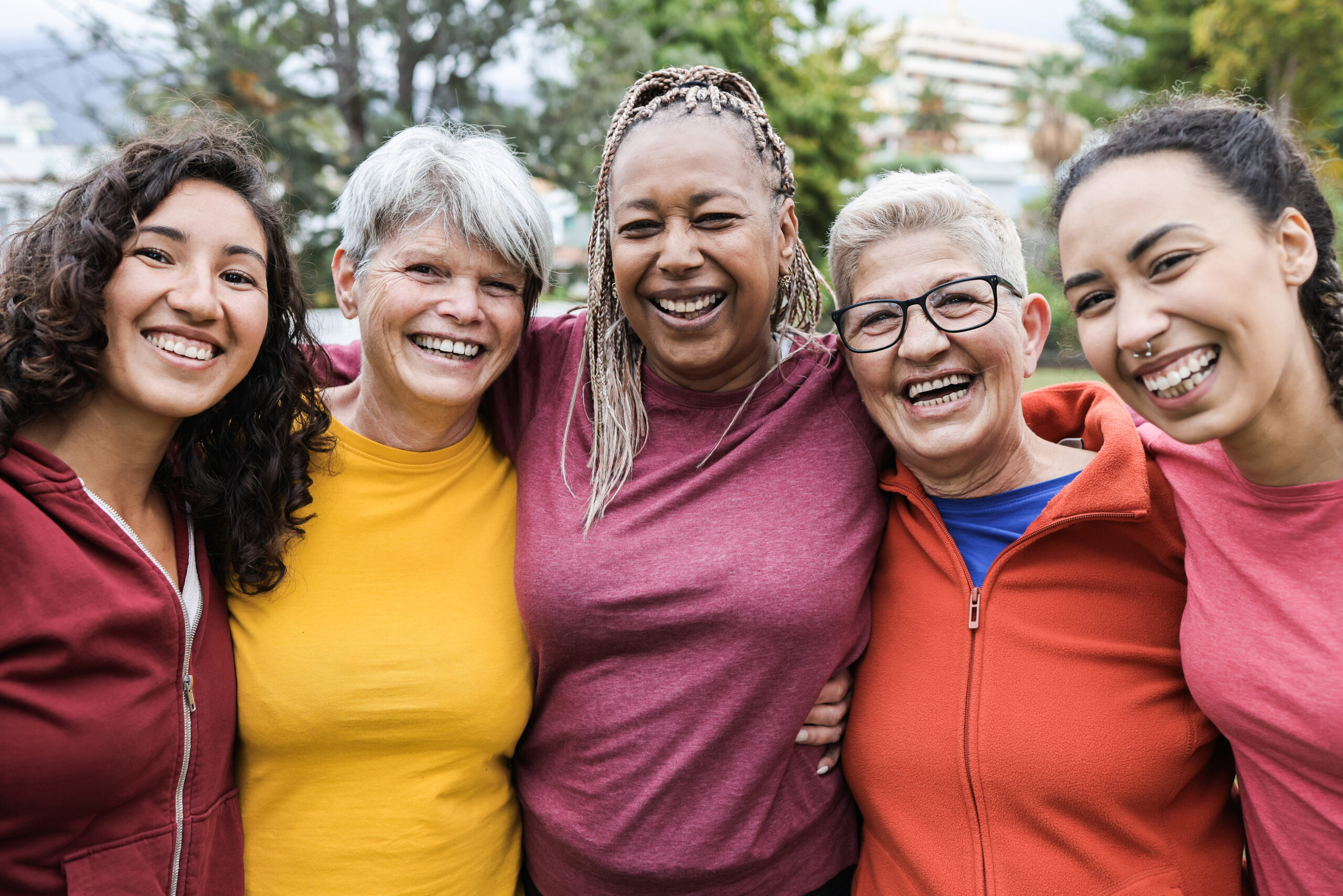 Happy multi generational women having fun together - Multiracial friends smiling on camera after sport workout outdoor - Main focus on african female face