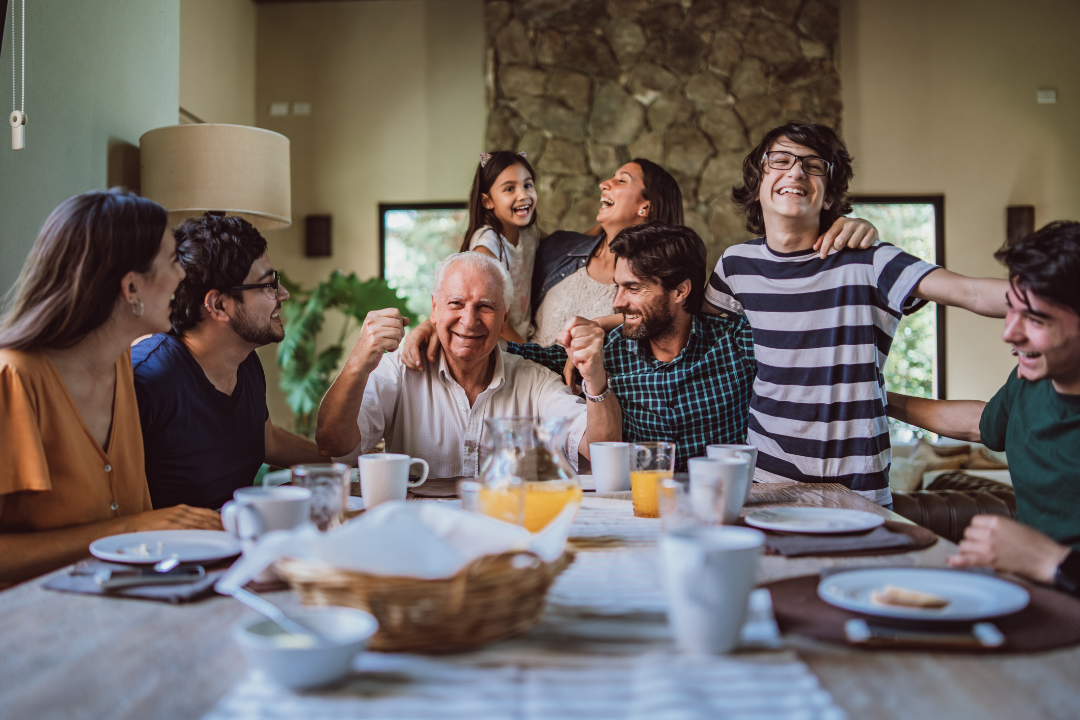 Happy grandfather surrounded with his family at breakfast