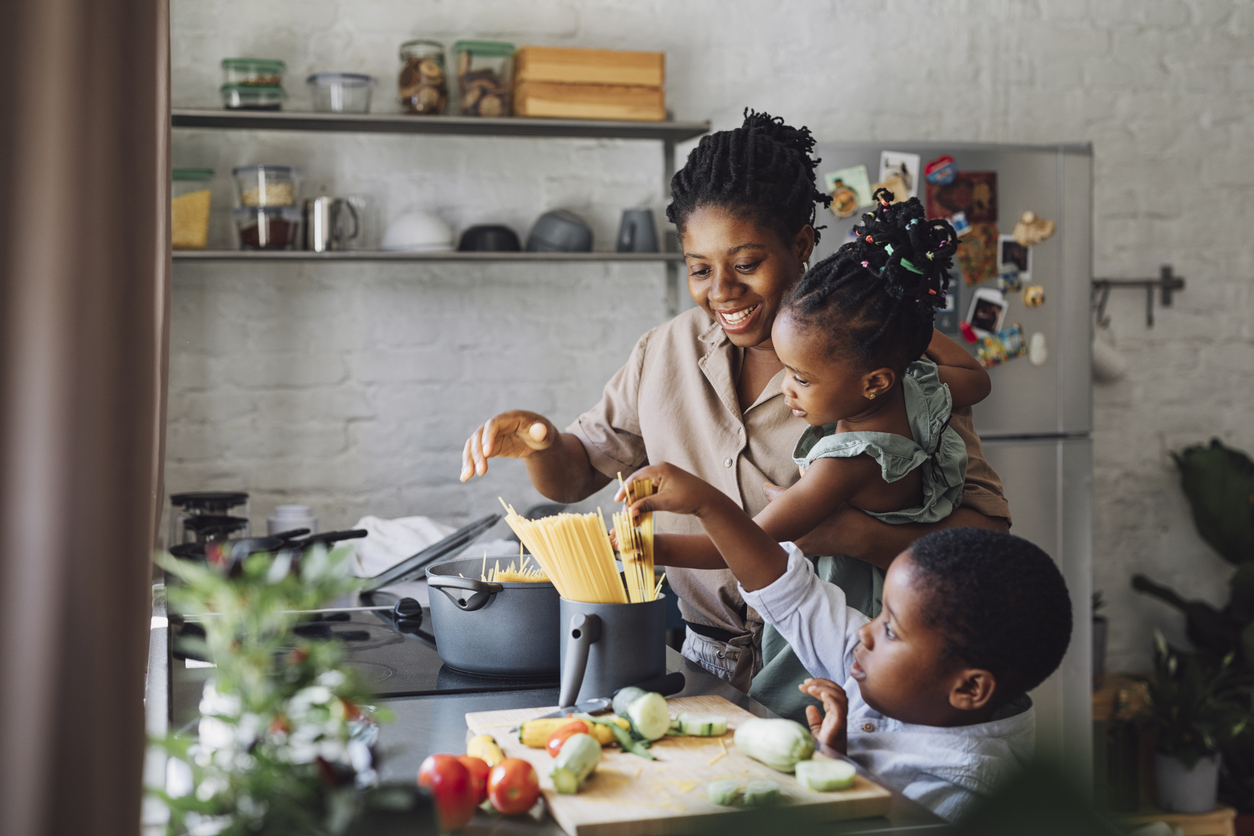 Mother, Daughter and Son Preparing Spaghetti and Vegetables for Lunch