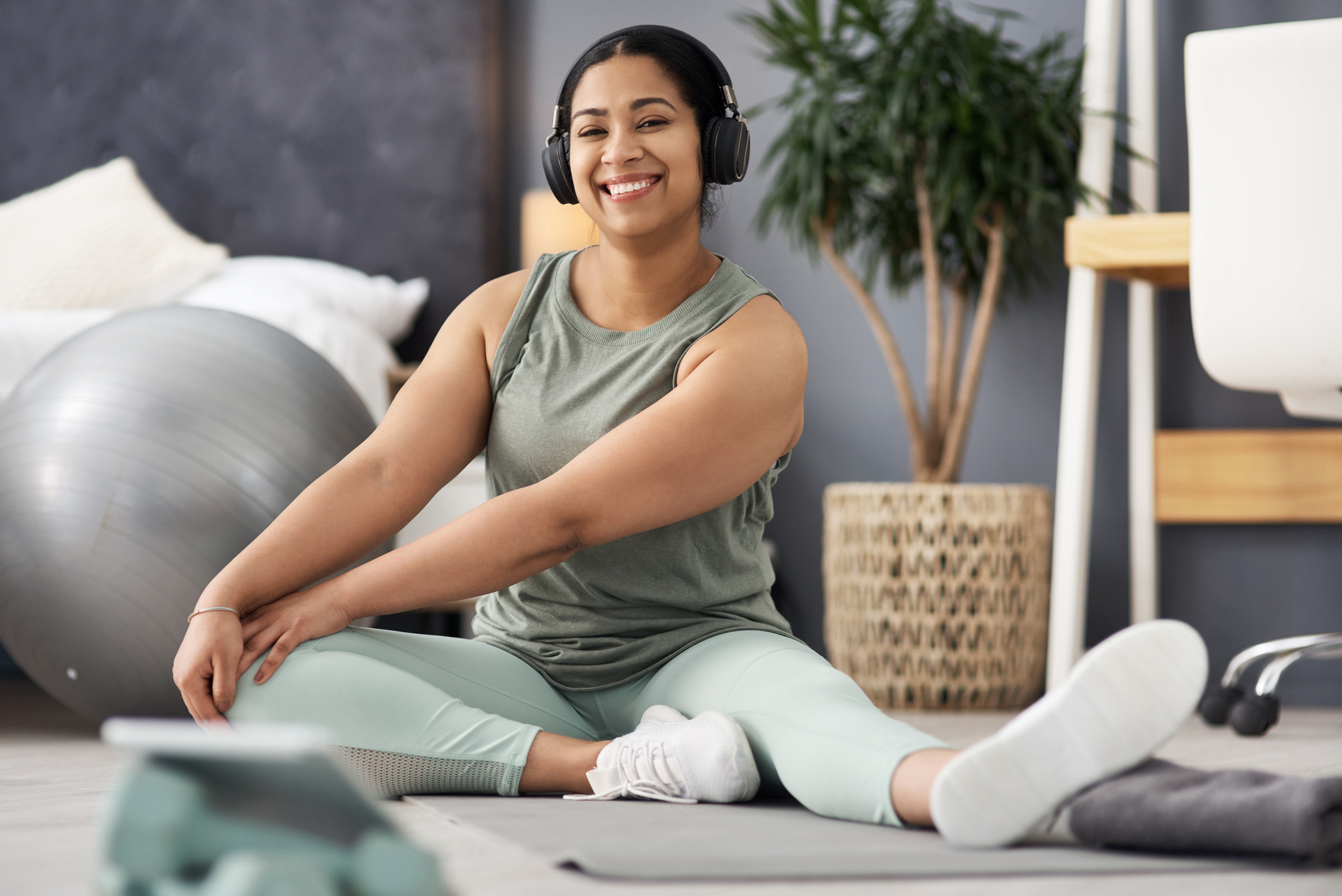 Portrait of a sporty young woman stretching her legs while exercising at home