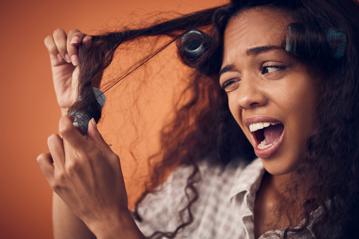 Shot of a woman pulling hair rollers out of her hair