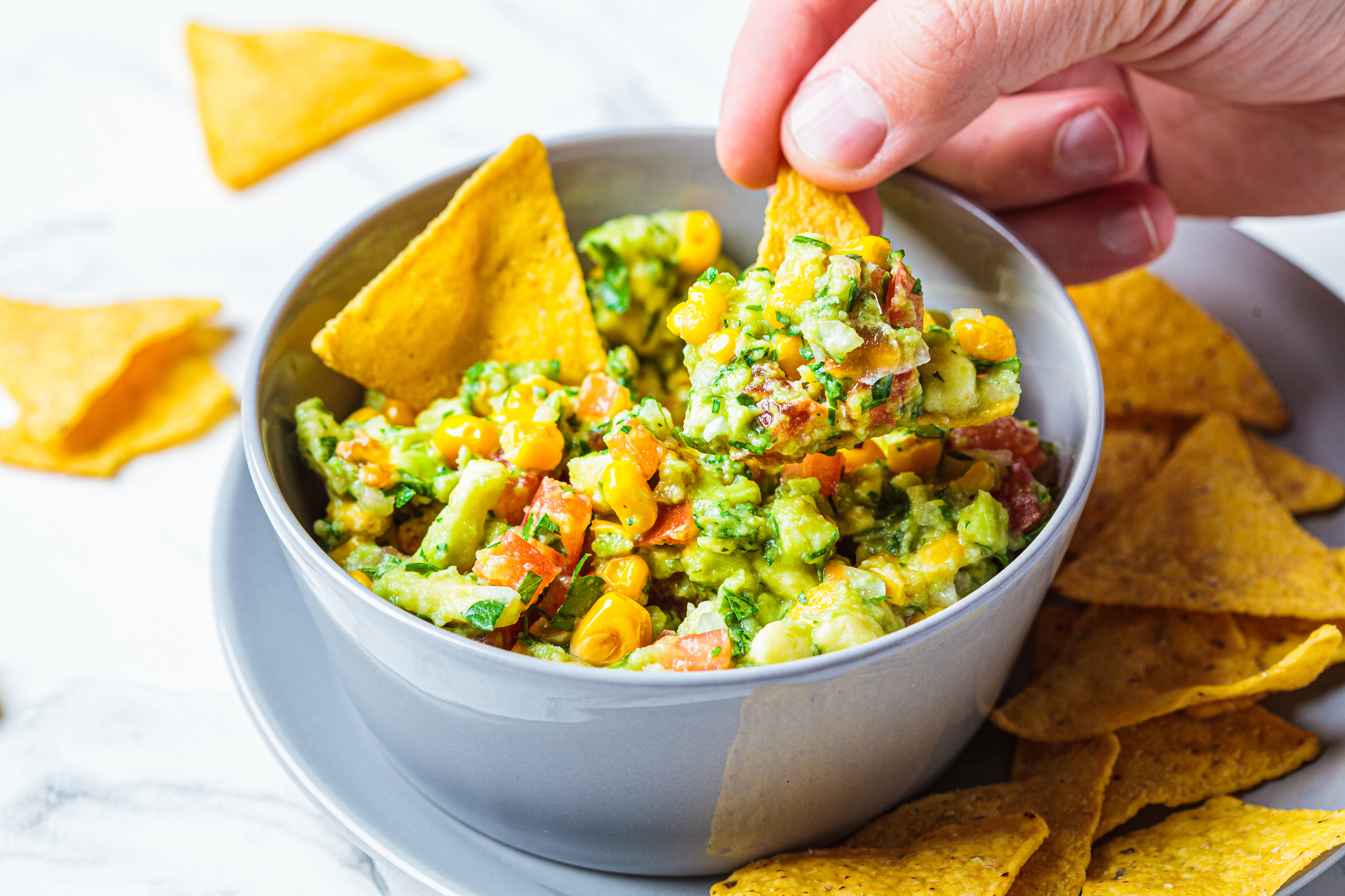 Avocado dip guacamole with grilled corn in gray bowl. Vegan food concept, Mexican cuisine.