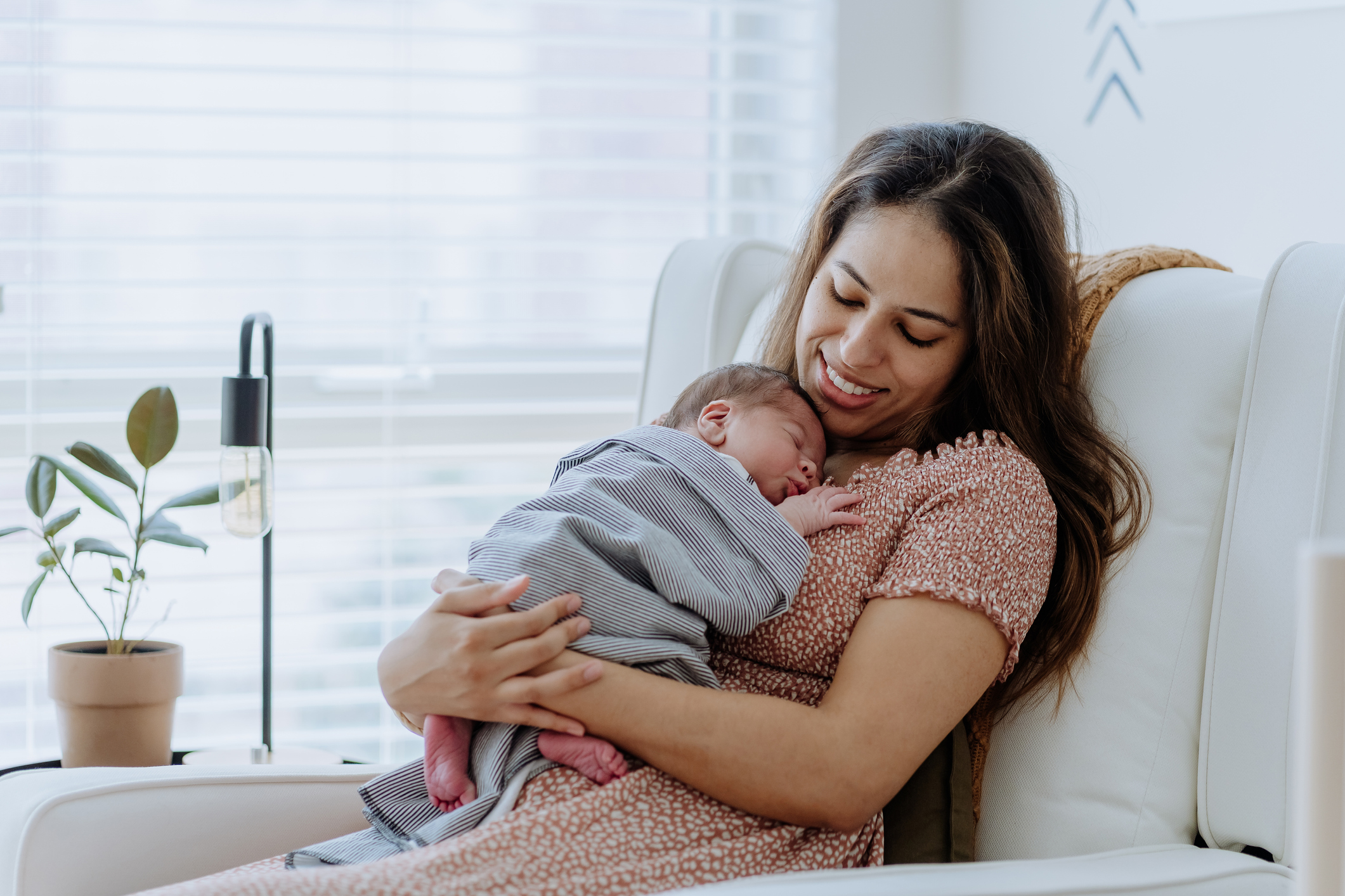 Mother holding her baby boy in the nursery room