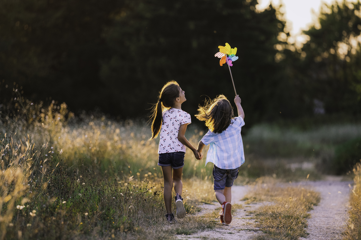 Happy Kids having fun with pinwheel in the nature. Running kids