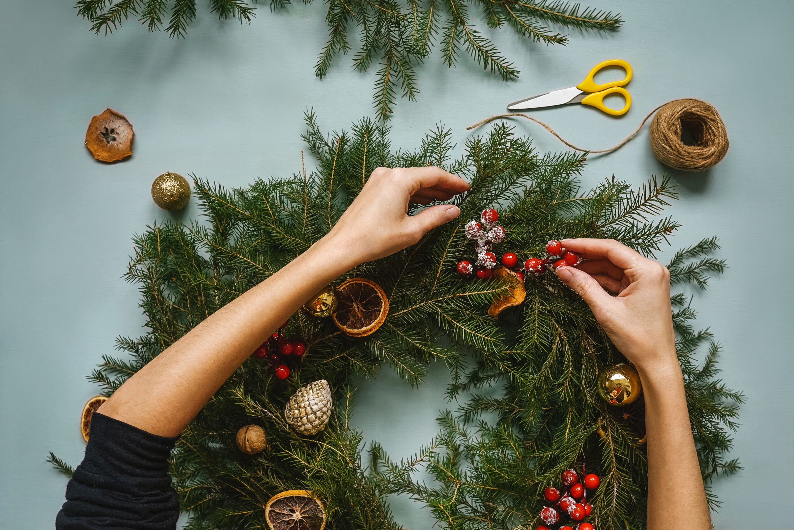 Woman making handmade christmas wreath. Top view.