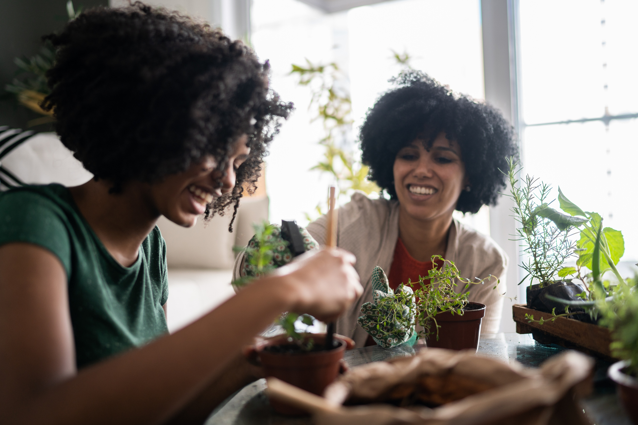 Mother and daughter taking care of plants together at home